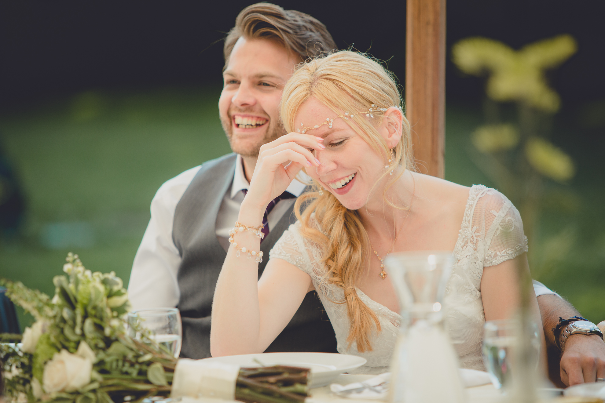 bride and groom laugh during speech under tent at reception at small wedding at Knox Farm near Buffalo, NY