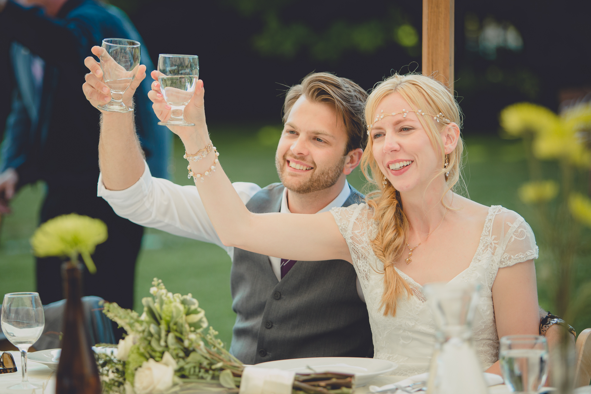 bride and groom cheers during speech under tent at reception at small wedding at Knox Farm near Buffalo, NY