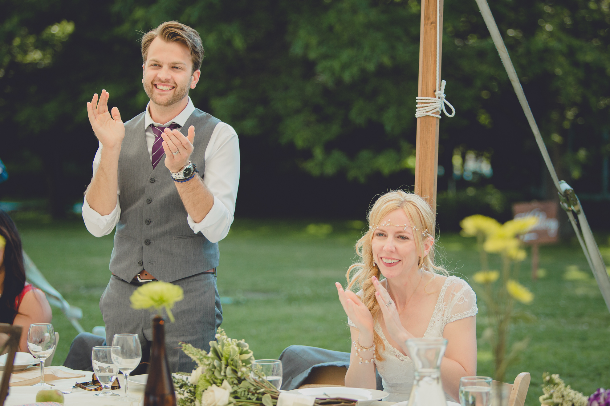 bride and groom clap after speech under tent at reception at small wedding at Knox Farm near Buffalo, NY
