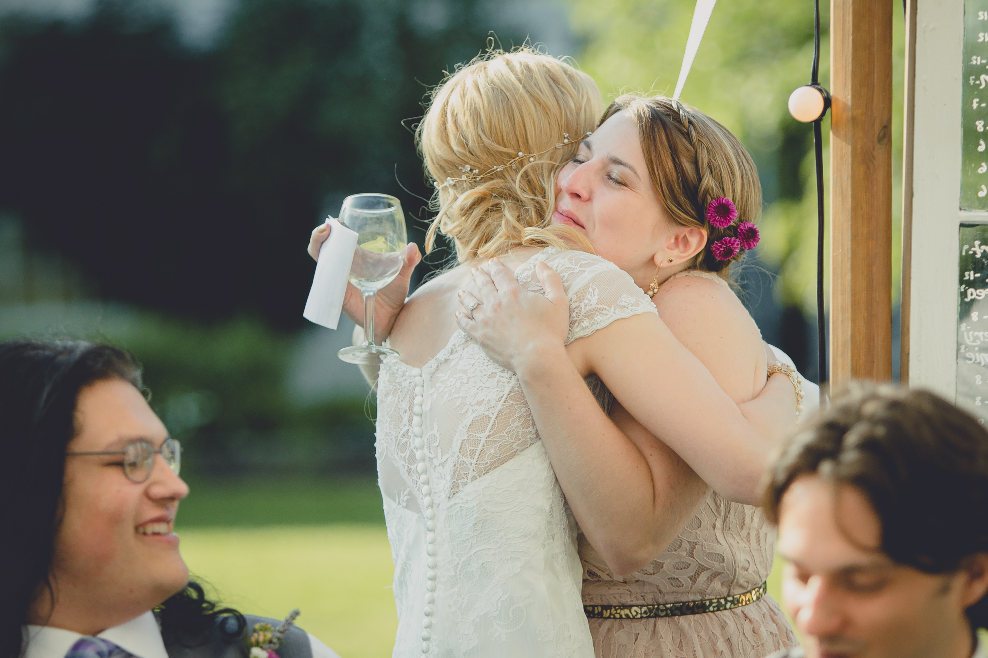 bride hugs maid of honor after speech under tent at reception at small wedding at Knox Farm near Buffalo, NY