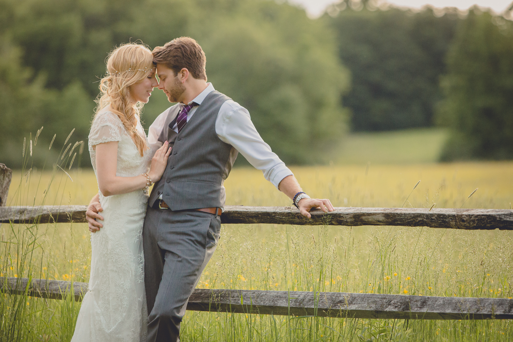 bride and groom pose for portraits in field during reception at small wedding venue Knox Farm in WNY