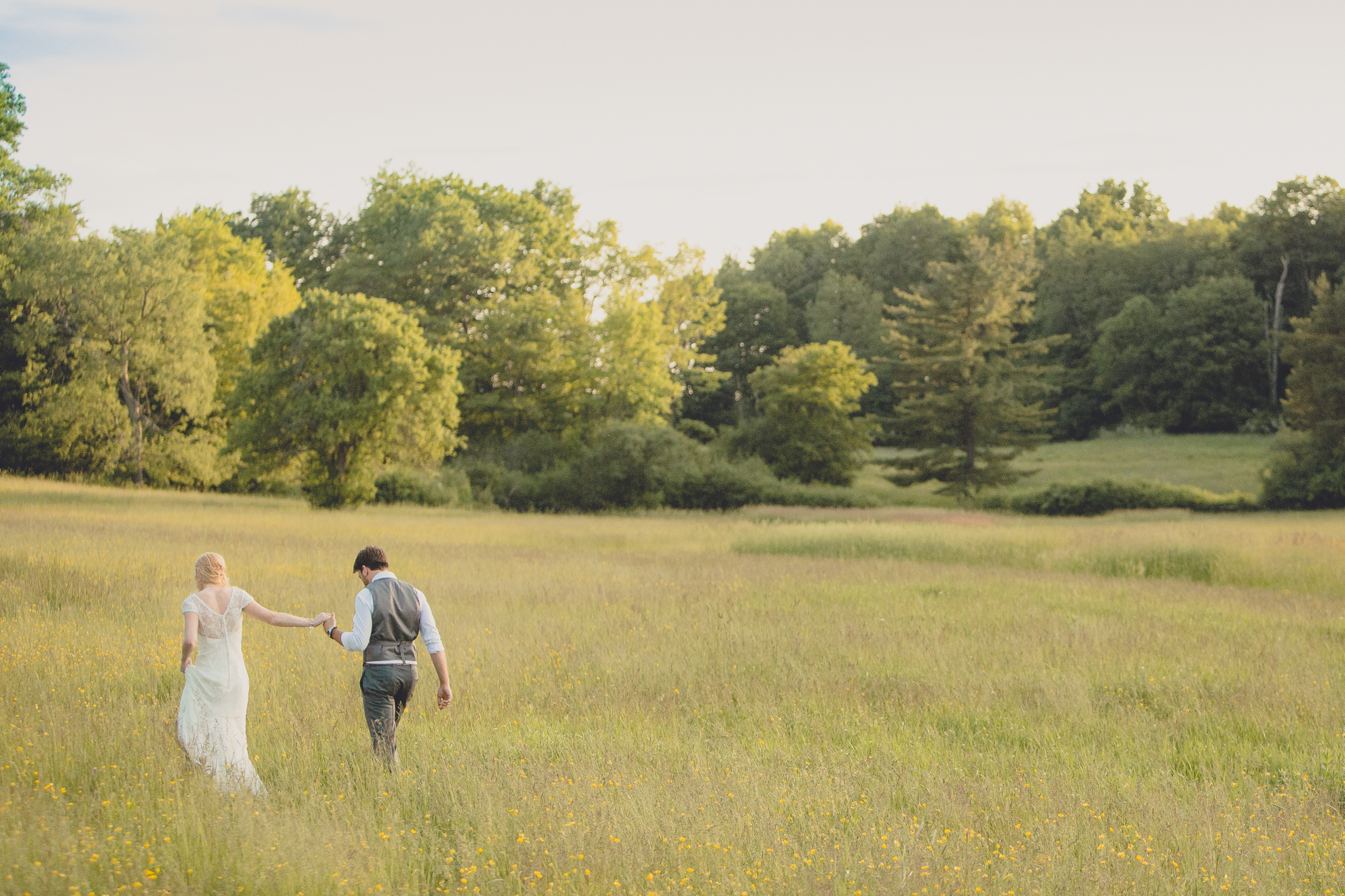 bride and groom pose for portraits in field during reception at wedding venue Knox Farm in WNY