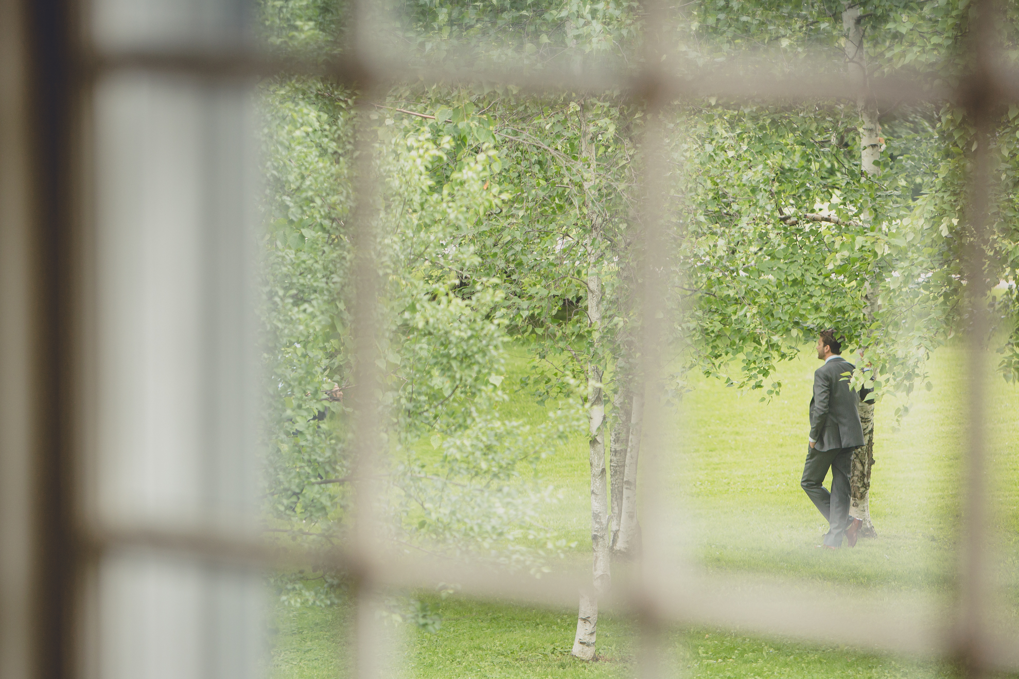 groom waits for bride outside mansion at their venue for first look, aka reveal, at their small wedding at Knox Farm near Buffalo, NY
