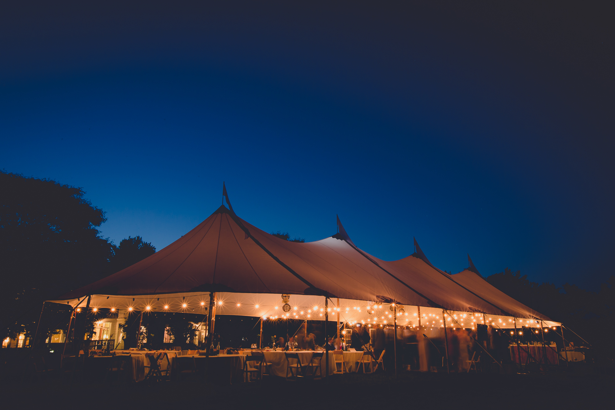 tent in field at night during tented reception at small wedding venue Knox Farm near Buffalo, NY