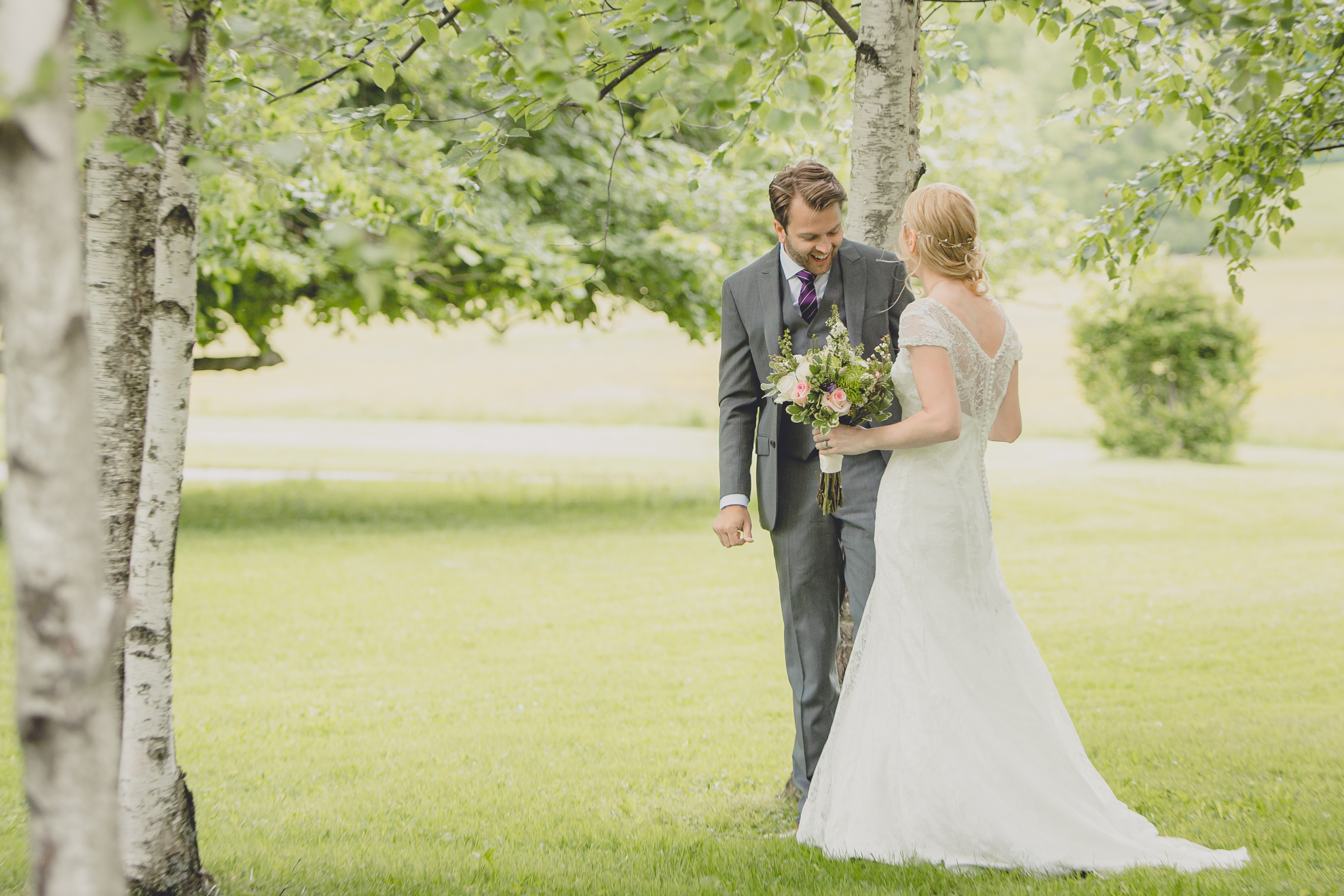bride walks up behind groom before their first look, aka reveal, at their small wedding at Knox Farm near Buffalo, NY