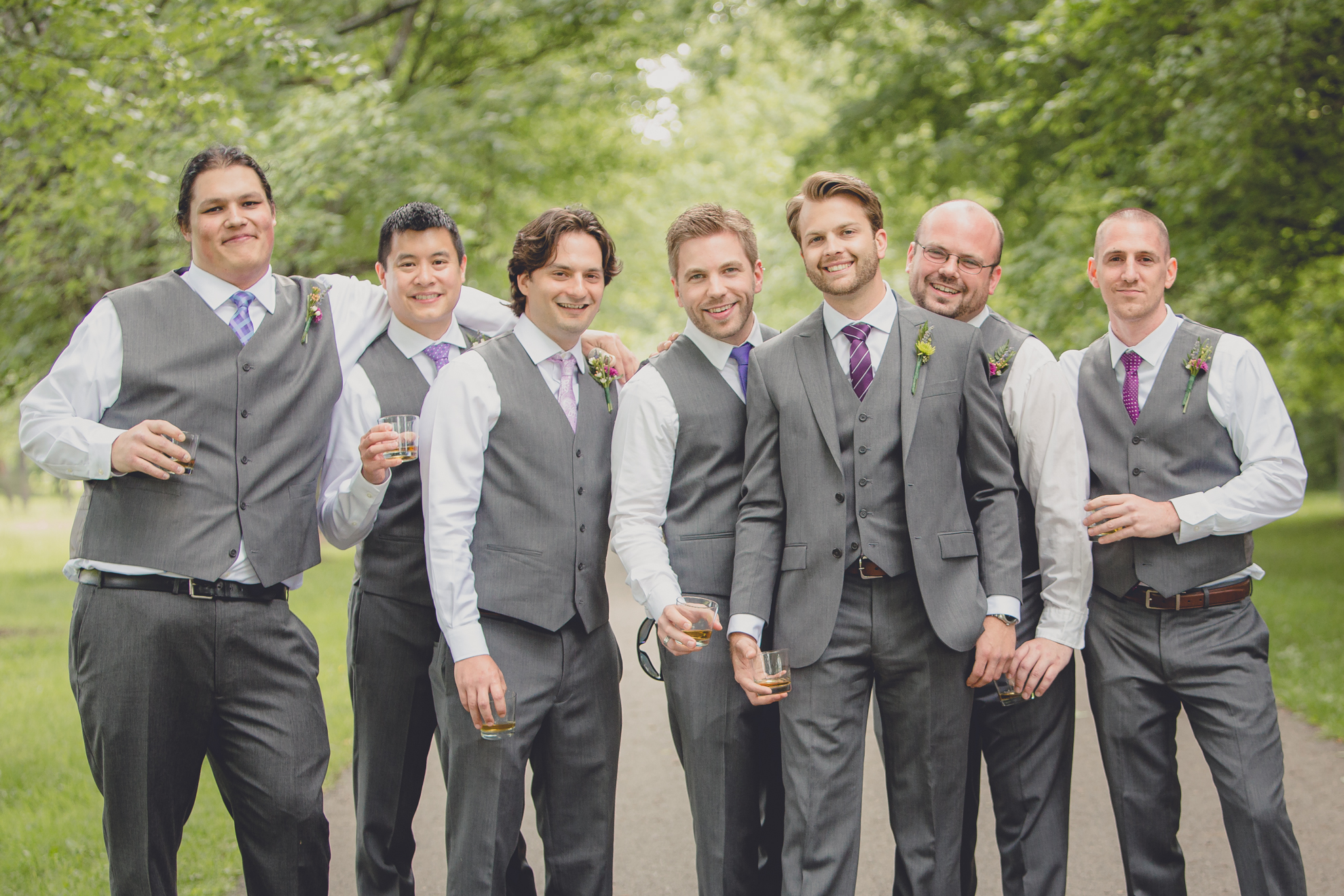 groomsmen pose for portraits on tree lined road at small wedding at Knox Farm near Buffalo, NY