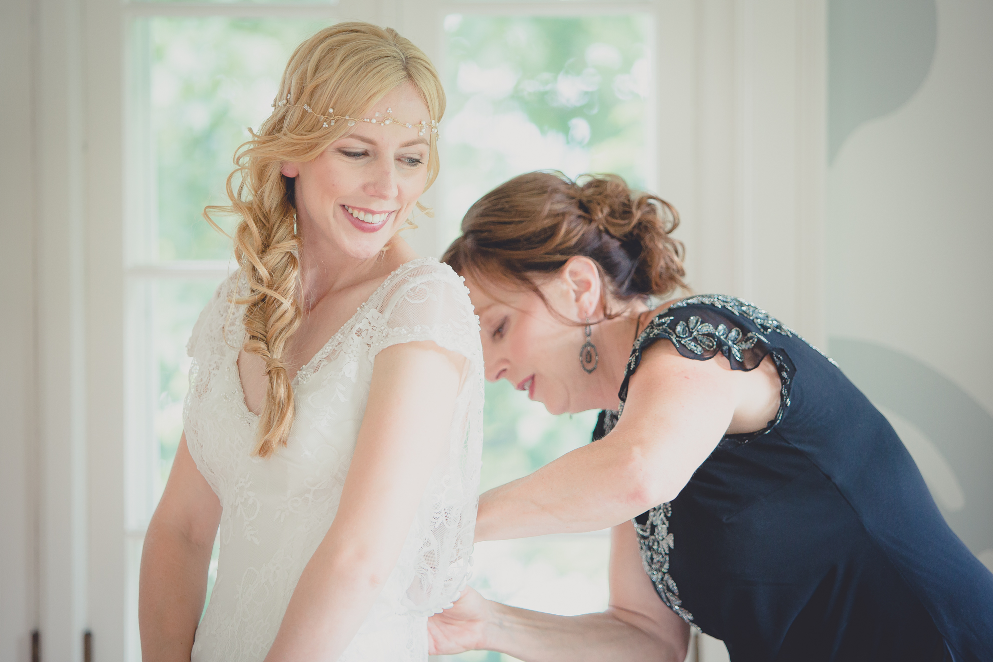mother of bride help bride get ready in secret room at small wedding at Knox Farm near Buffalo, NY