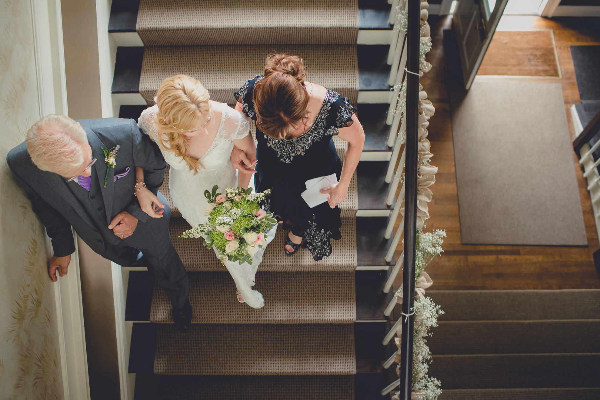 parents of bride walk her down stairs before ceremony at small wedding at Knox Farm near Buffalo, NY
