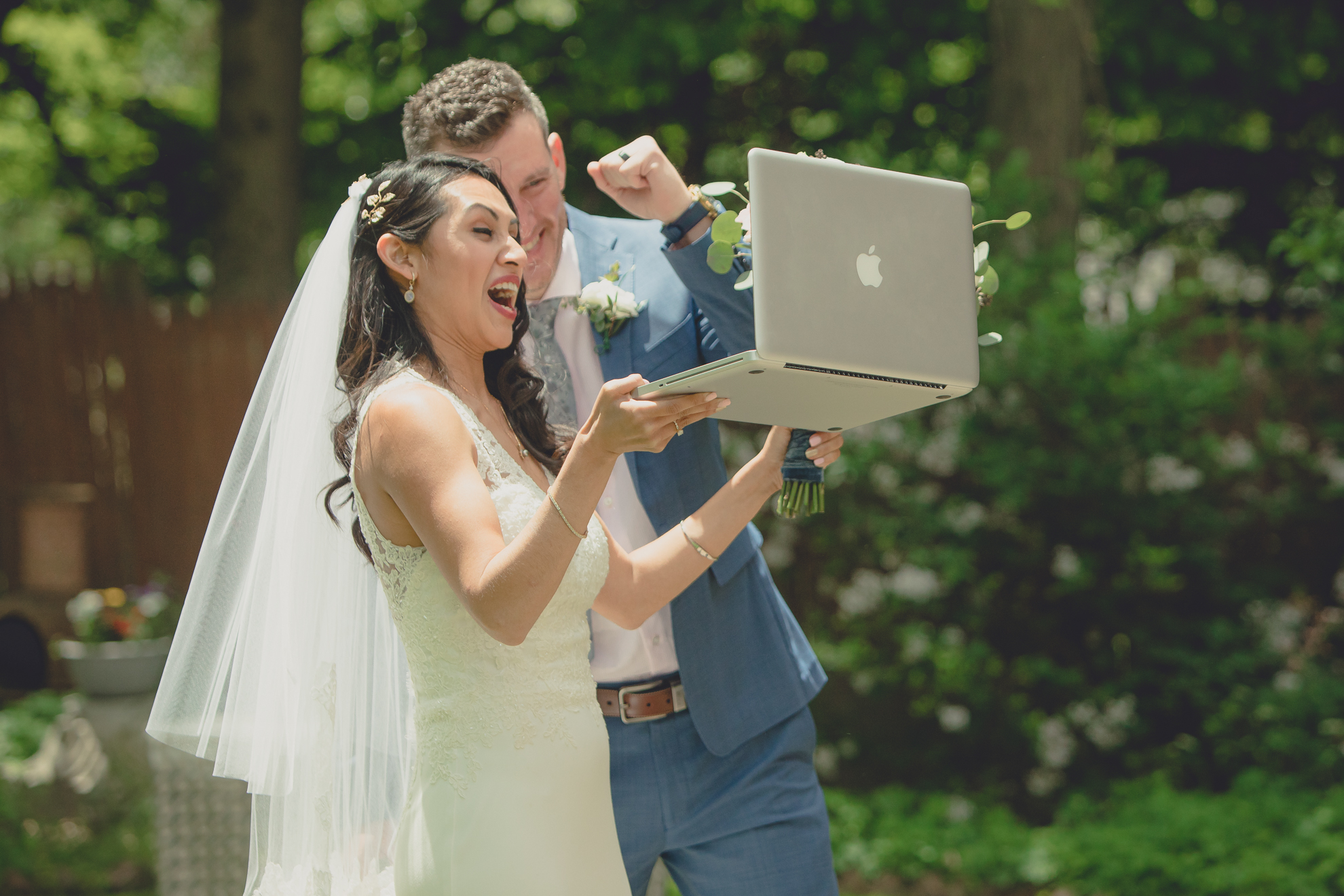 bride and groom cheer for guests on zoom video call after small backyard micro wedding in Buffalo, NY