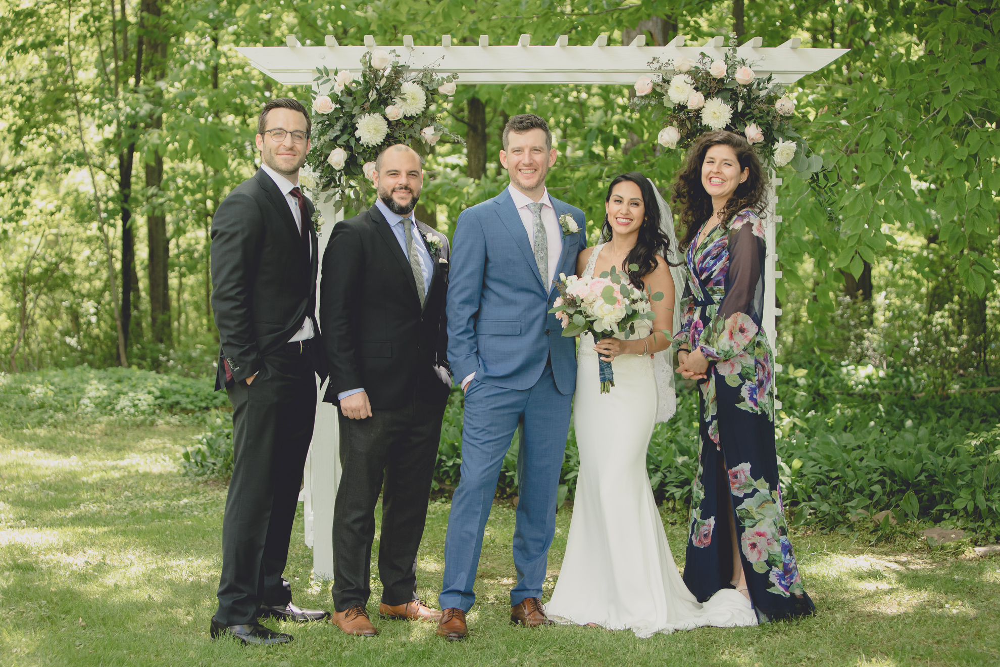 wedding party smiles at photographer for portrait after small backyard micro wedding ceremony in Buffalo, NY