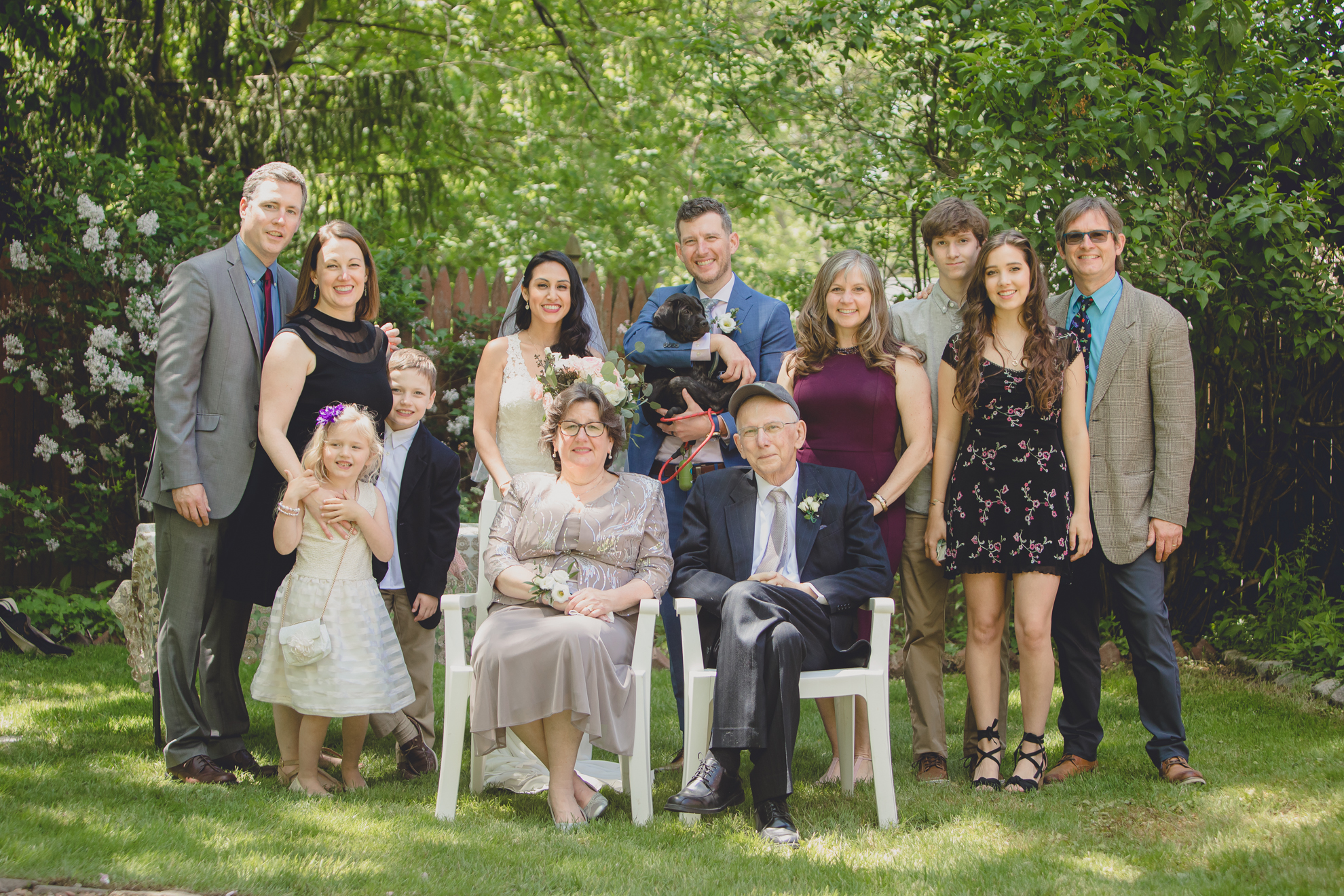 family smiles for photographer in portrait after small backyard micro wedding ceremony in Buffalo, NY