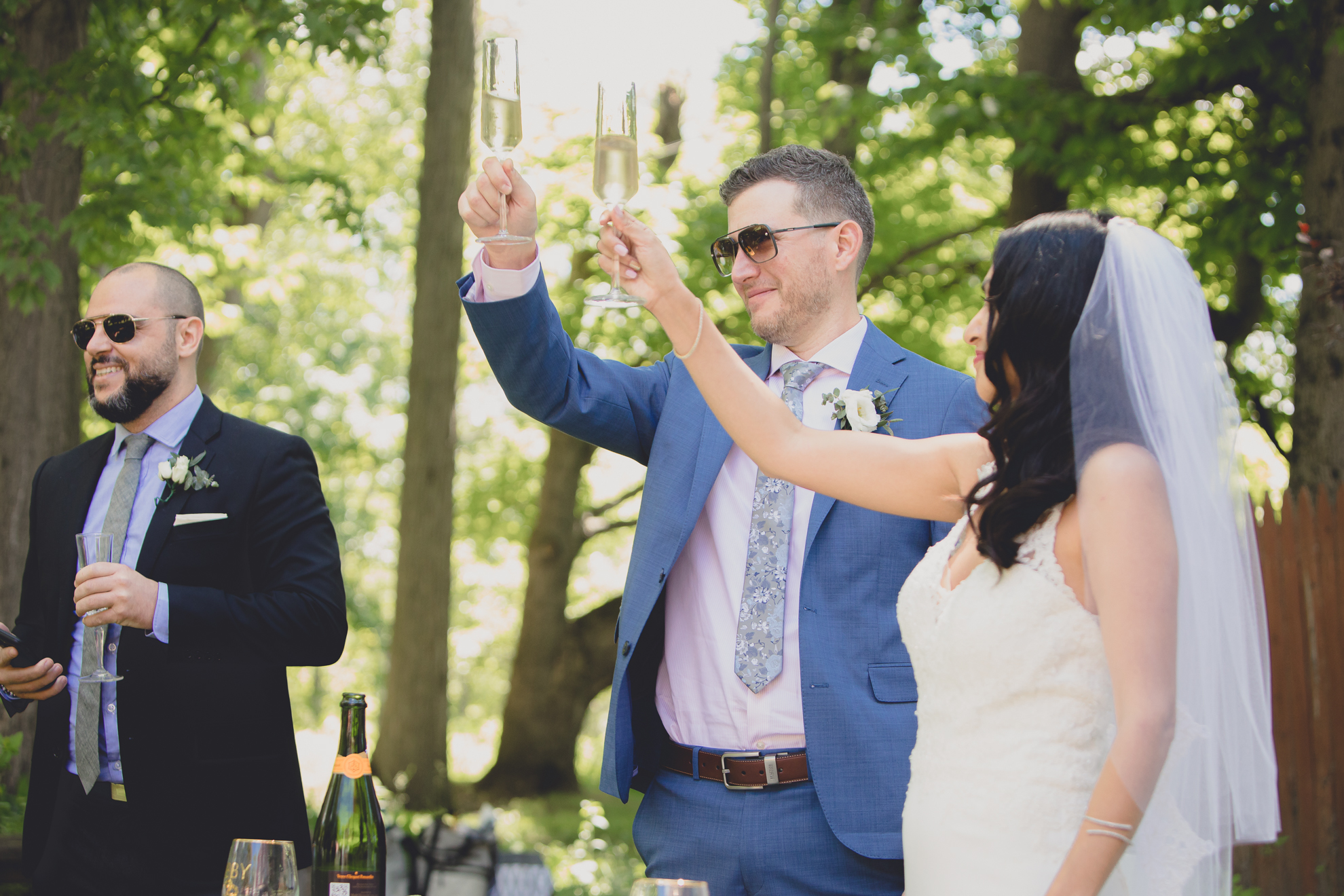 bride and groom cheers during small backyard intimate wedding reception in Buffalo, NY