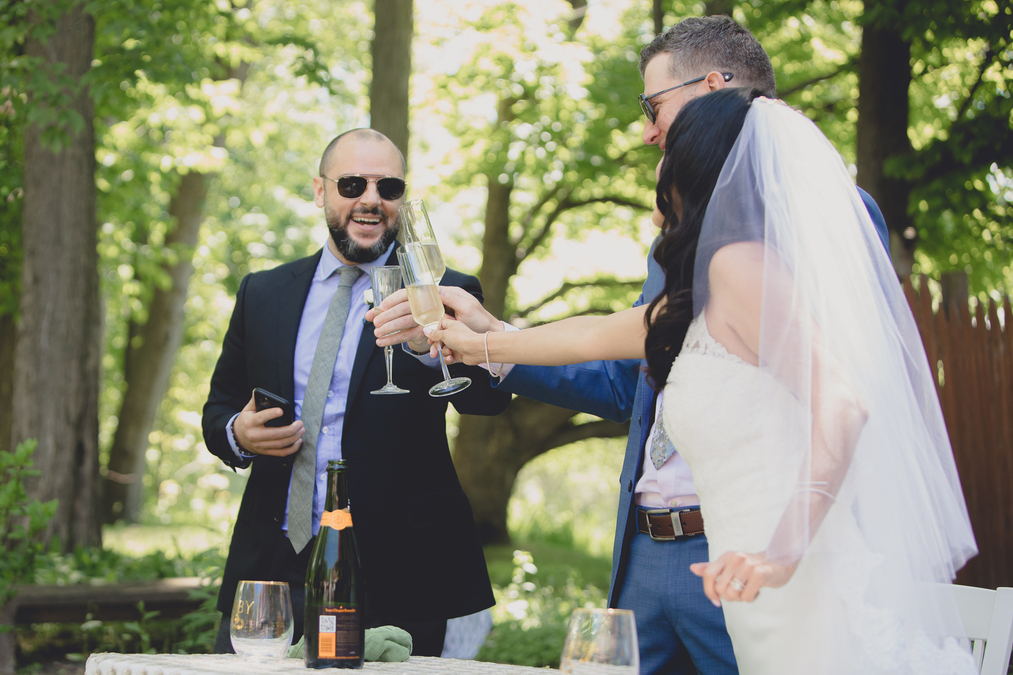 best man toasts bride and groom during small backyard intimate wedding reception in Buffalo, NY