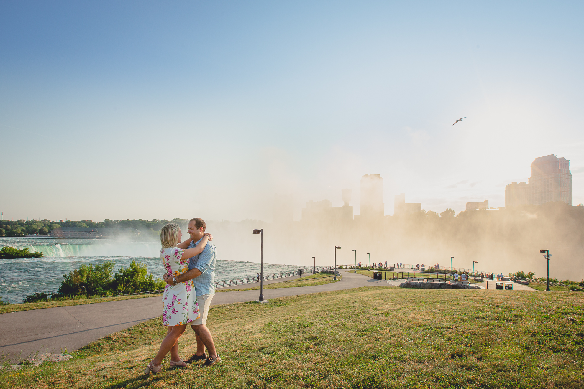 engaged couple embraces with Niagara Falls in the background during wedding engagement photography session 