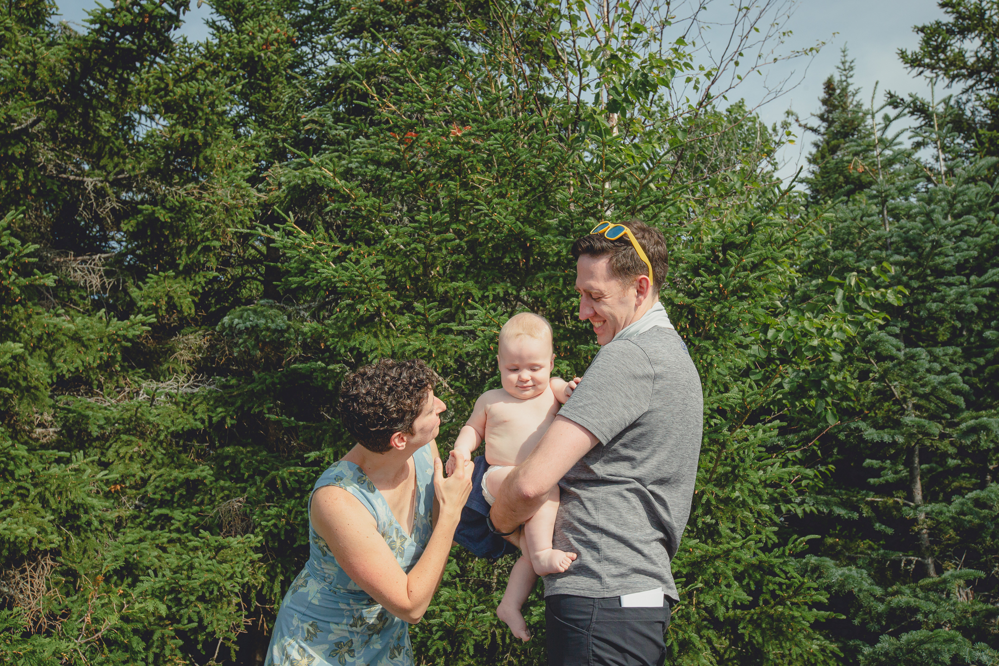 mom and dad change baby on top of Mount Jo during their photojournalistic family photography session in the Adirondack High Peaks Region of NY