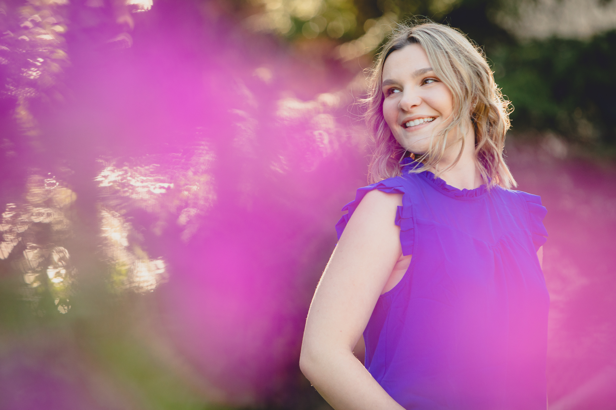 maple grove high school student smiles poses for photographer in garden during senior pictures at Chautauqua Institution