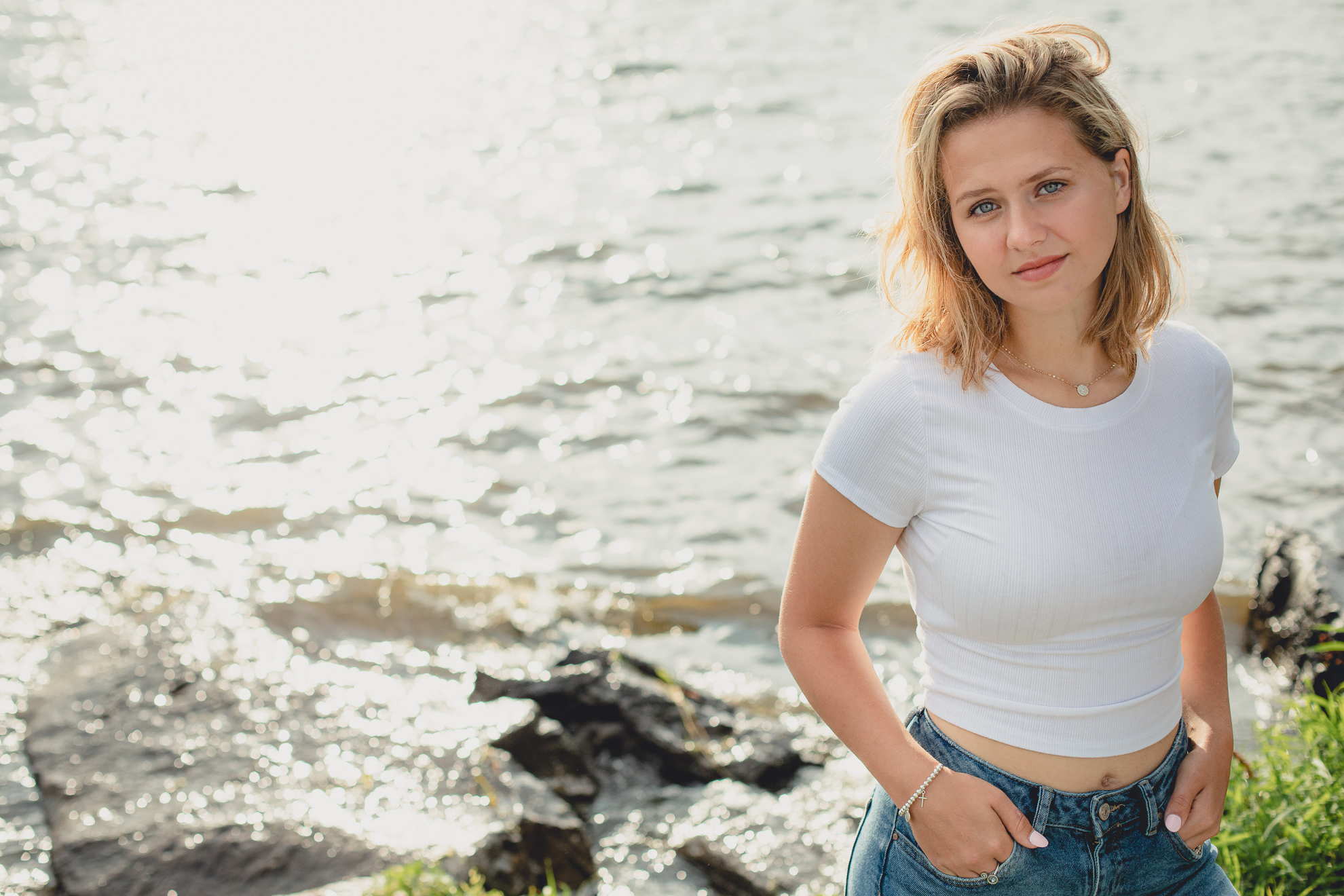 wny student smiles at camera during senior portrait photography session at Long Point State Park on Lake Chautauqua in Bemus Point, NY