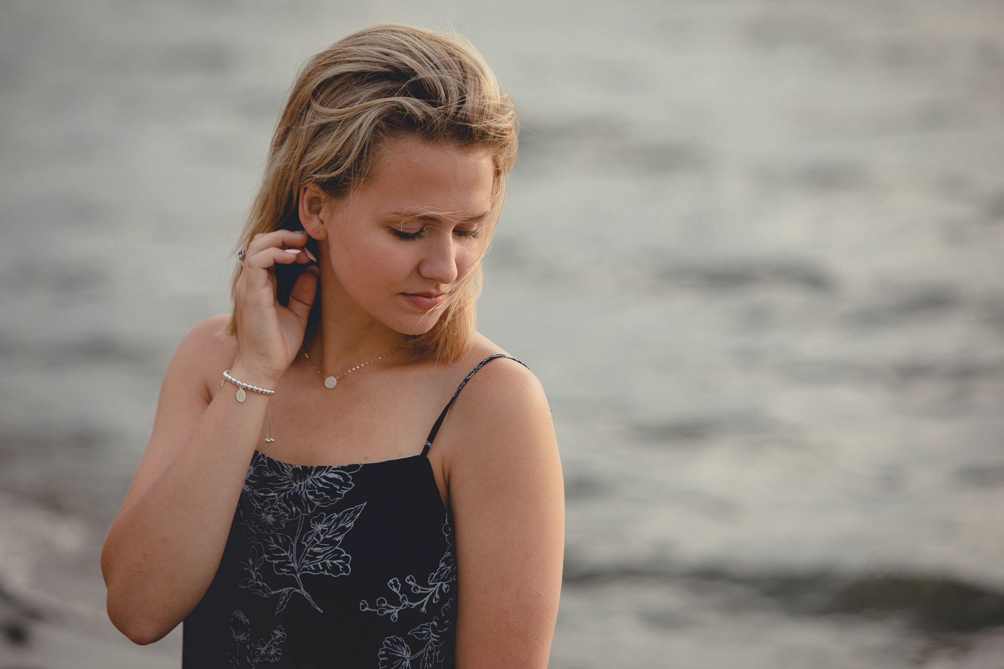 student fixes hair during senior portrait photography session at Long Point State Park on Lake Chautauqua in Bemus Point, NY