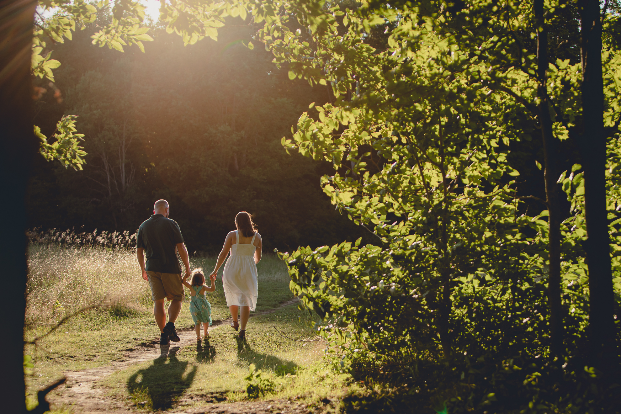 family holds hands while walking on path during family portrait photography session at Knox Farm in East Aurora, a small town near Buffalo