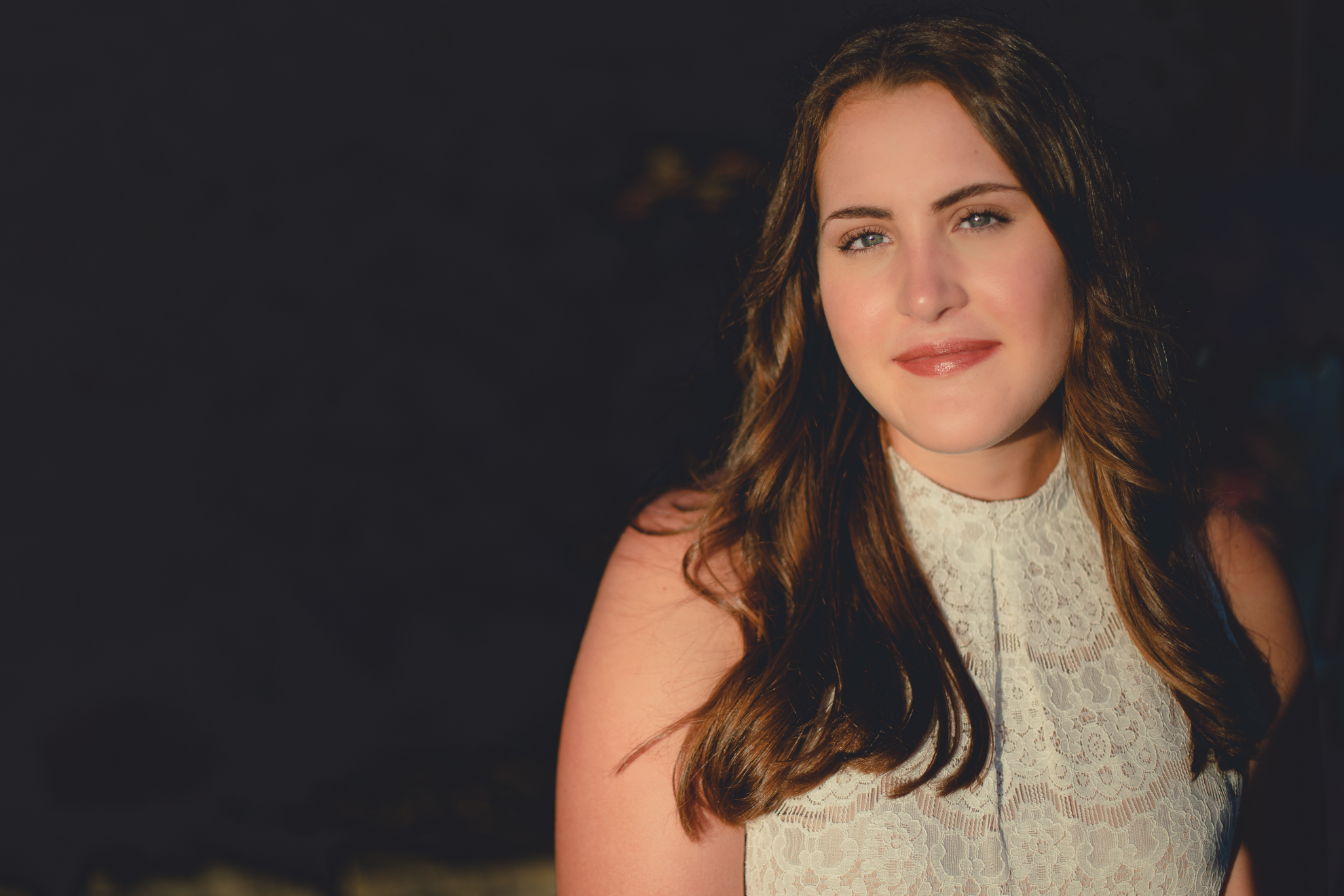 Tessa in sunset golden hour light in front yard during senior portrait photography session near Buffalo, NY