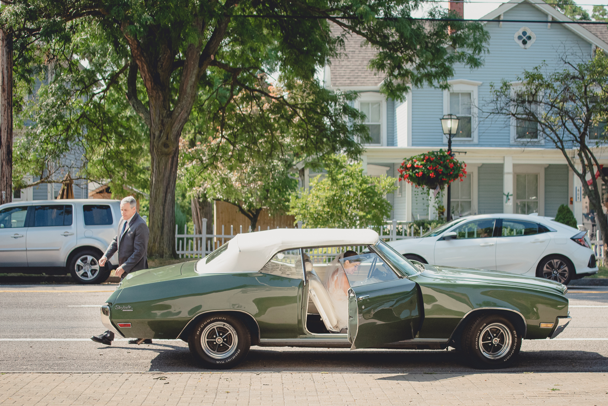 father escorts bride out of vintage Buick before micro wedding ceremony in Lewiston, NY