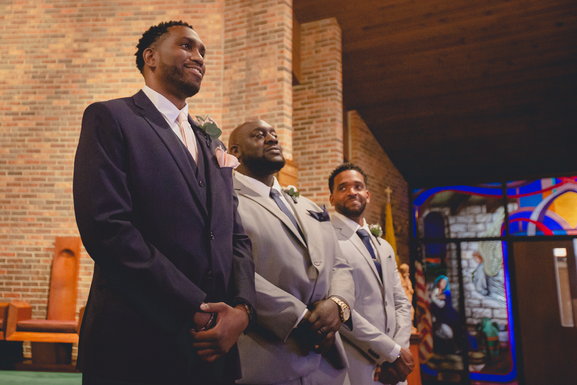 groom smiles and waits for bride at end of aisle during micro wedding ceremony at St. Peter's Church in Lewiston, NY