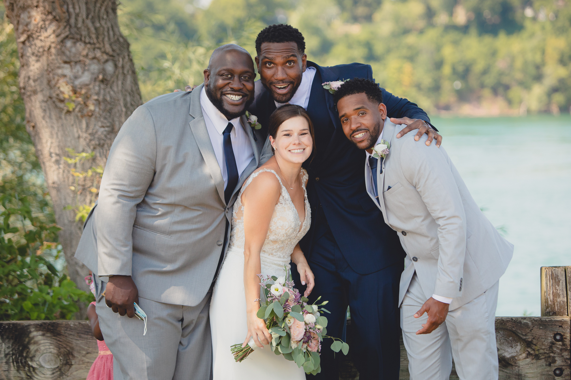 bride, groom families and wedding party smile for photographer during wedding portraits at Lewiston Landing during WNY micro wedding