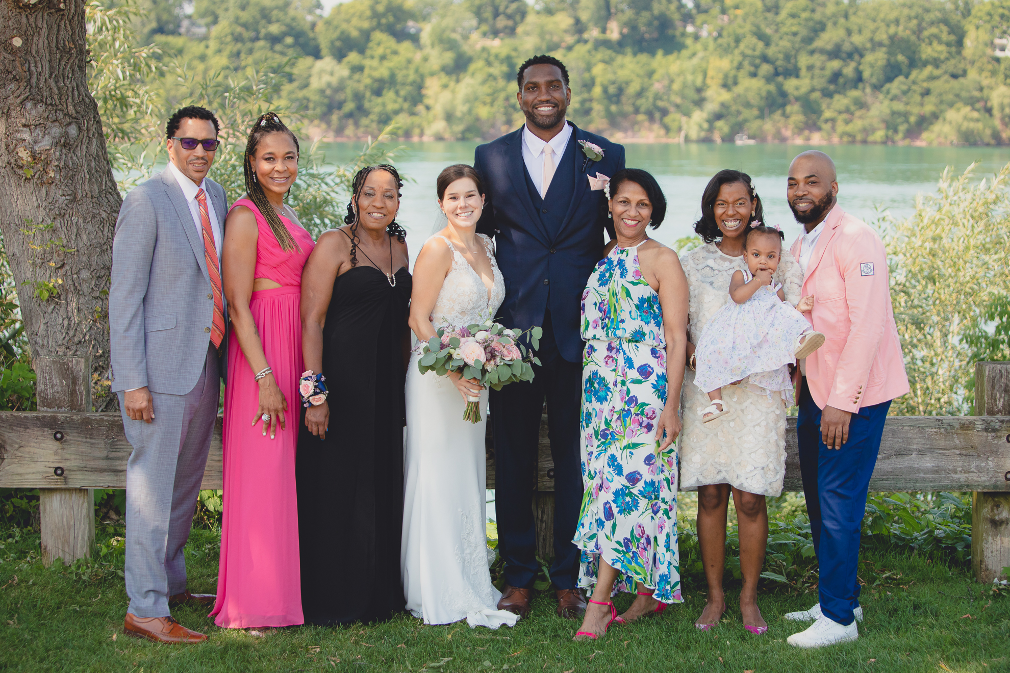 bride, groom families and wedding party smile for photographer during wedding portraits at Lewiston Landing during WNY micro wedding