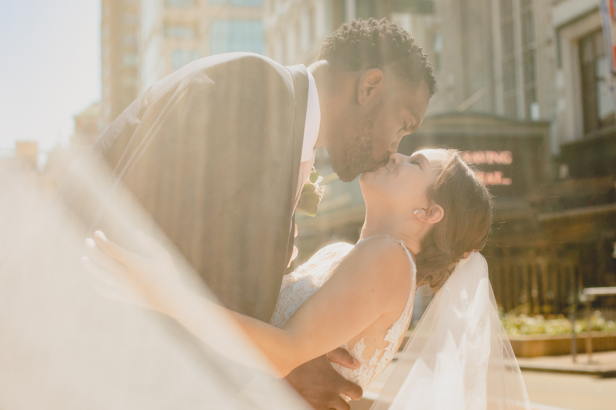 bride and groom kiss in theater district of Buffalo, NY near Shea's Theater during WNY micro wedding celebration