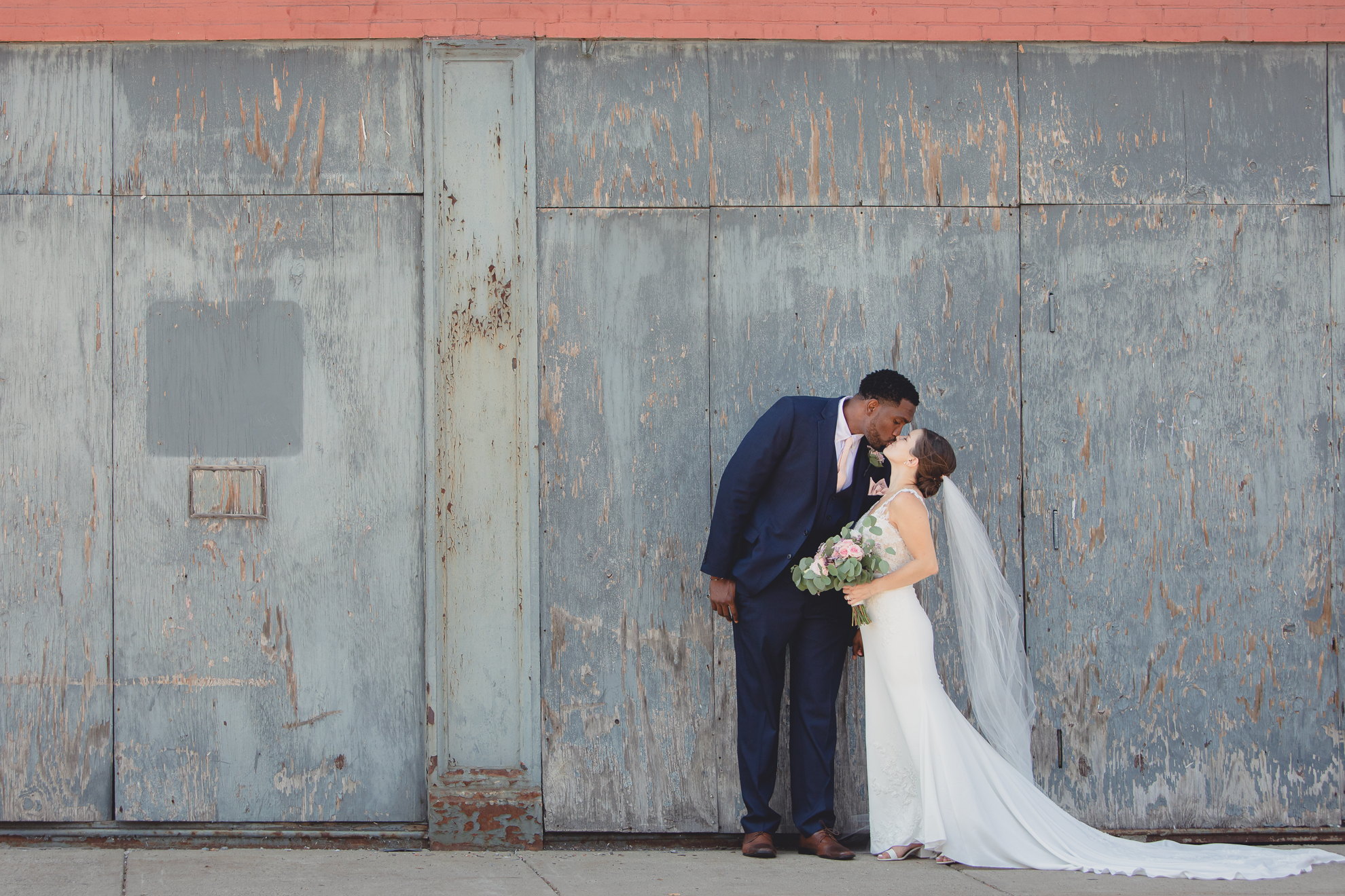 bride and groom kiss in theater district of Buffalo, NY near Shea's Theater during WNY micro wedding celebration