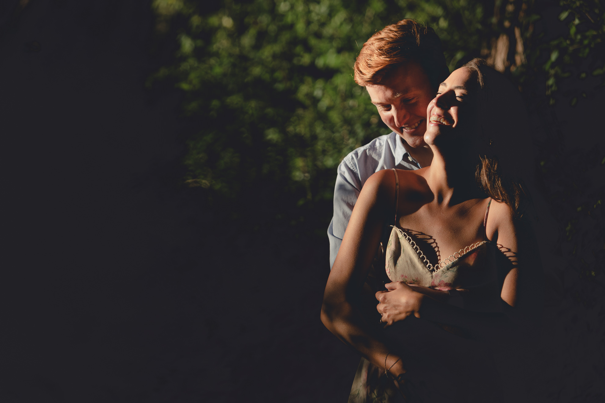 bride laughs as groom hugs her from behind during wedding engagement portrait photography session at tifft nature preserve in Buffalo, NY