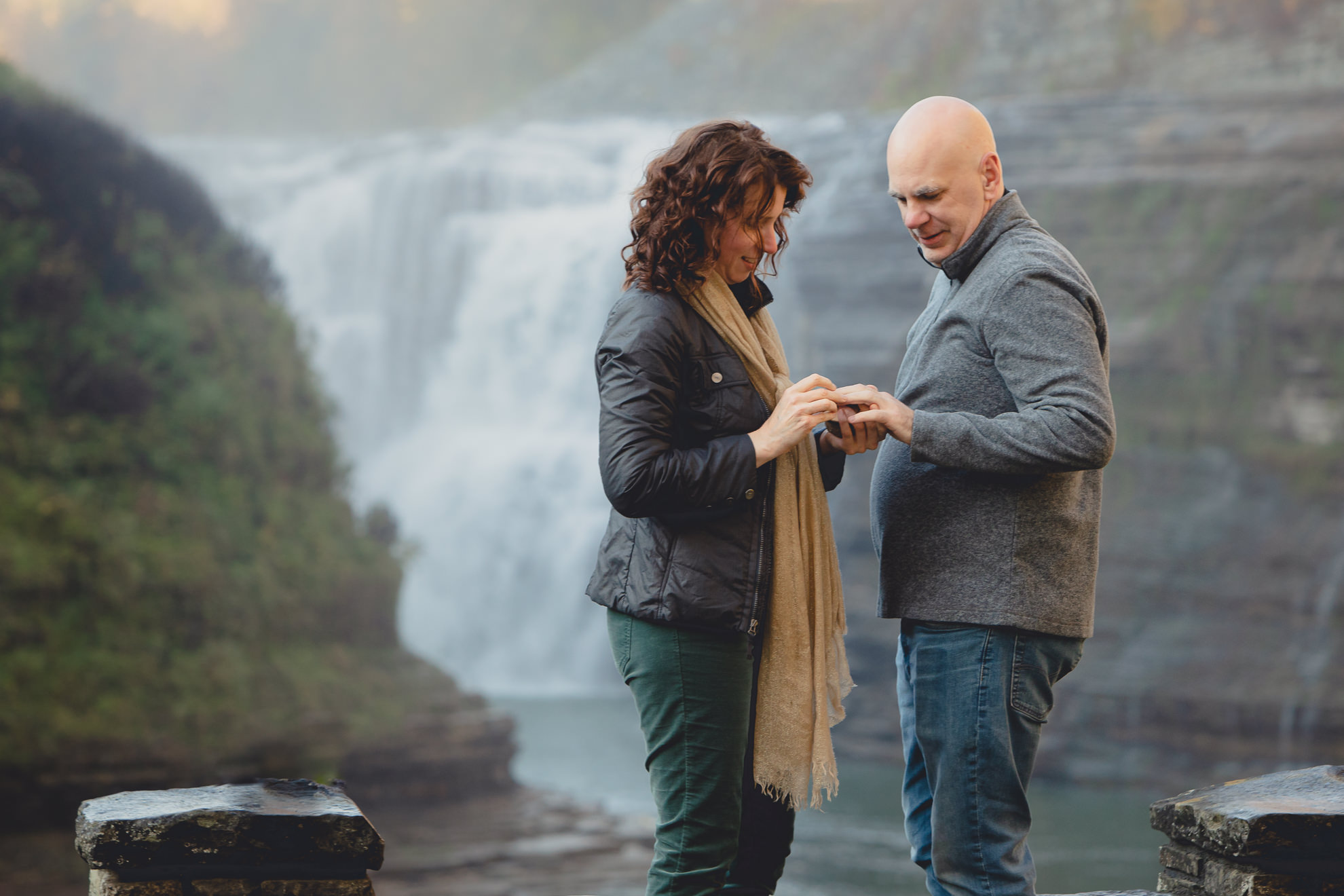 bride proposes to groom and places ring on his finger in front of Upper Falls at Letchworth State Park near Buffalo, NY