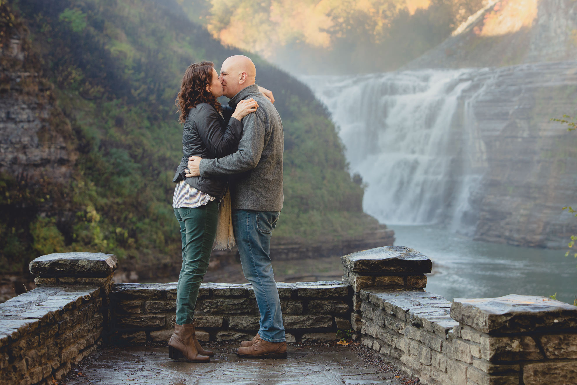 bride and groom kiss after proposal in front of Upper Falls at Letchworth State Park near Buffalo, NY