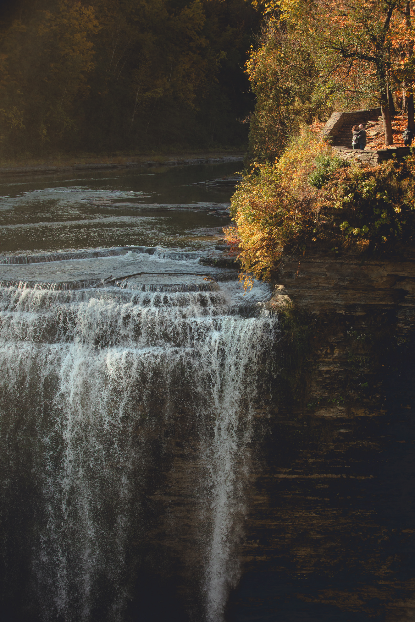 bride and groom pose with foreheads touching after wedding proposal next to Middle Falls at Letchworth State Park near Buffalo, NY