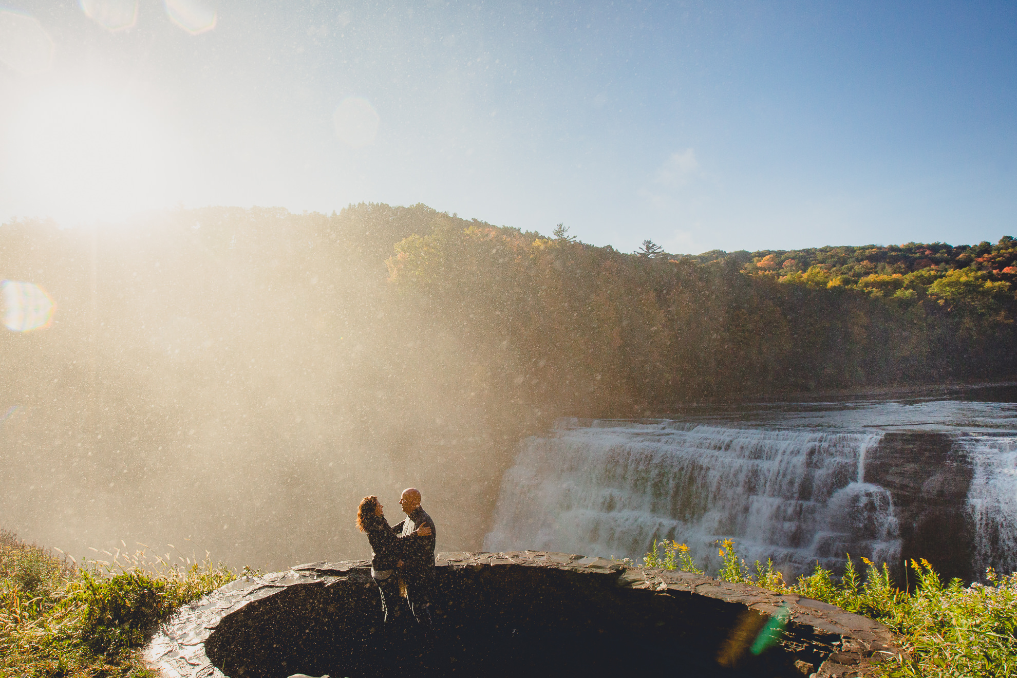 bride and groom laugh after wedding proposal next to Middle Falls at Letchworth State Park near Buffalo, NY