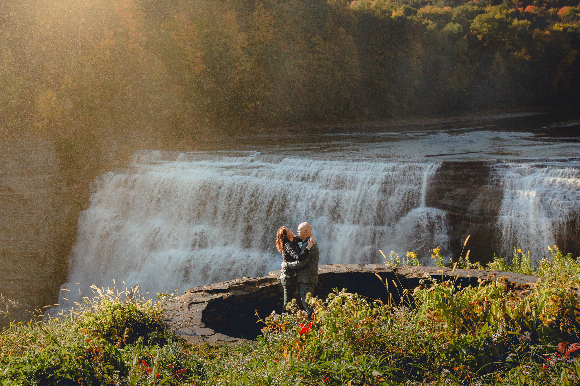 bride and groom laugh after wedding proposal next to Middle Falls at Letchworth State Park near Buffalo, NY