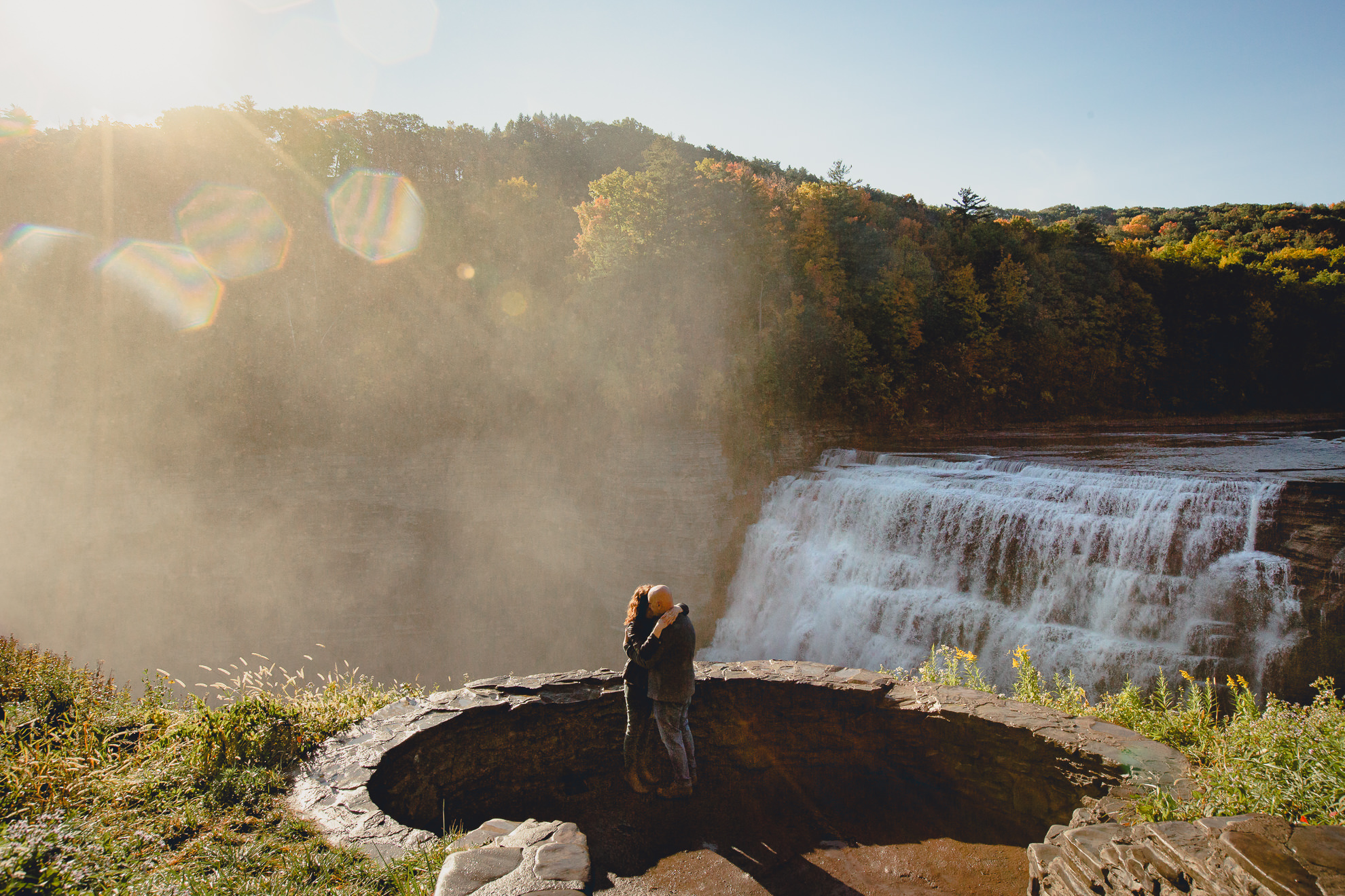 bride and groom hug after wedding proposal next to Middle Falls at Letchworth State Park near Buffalo, NY