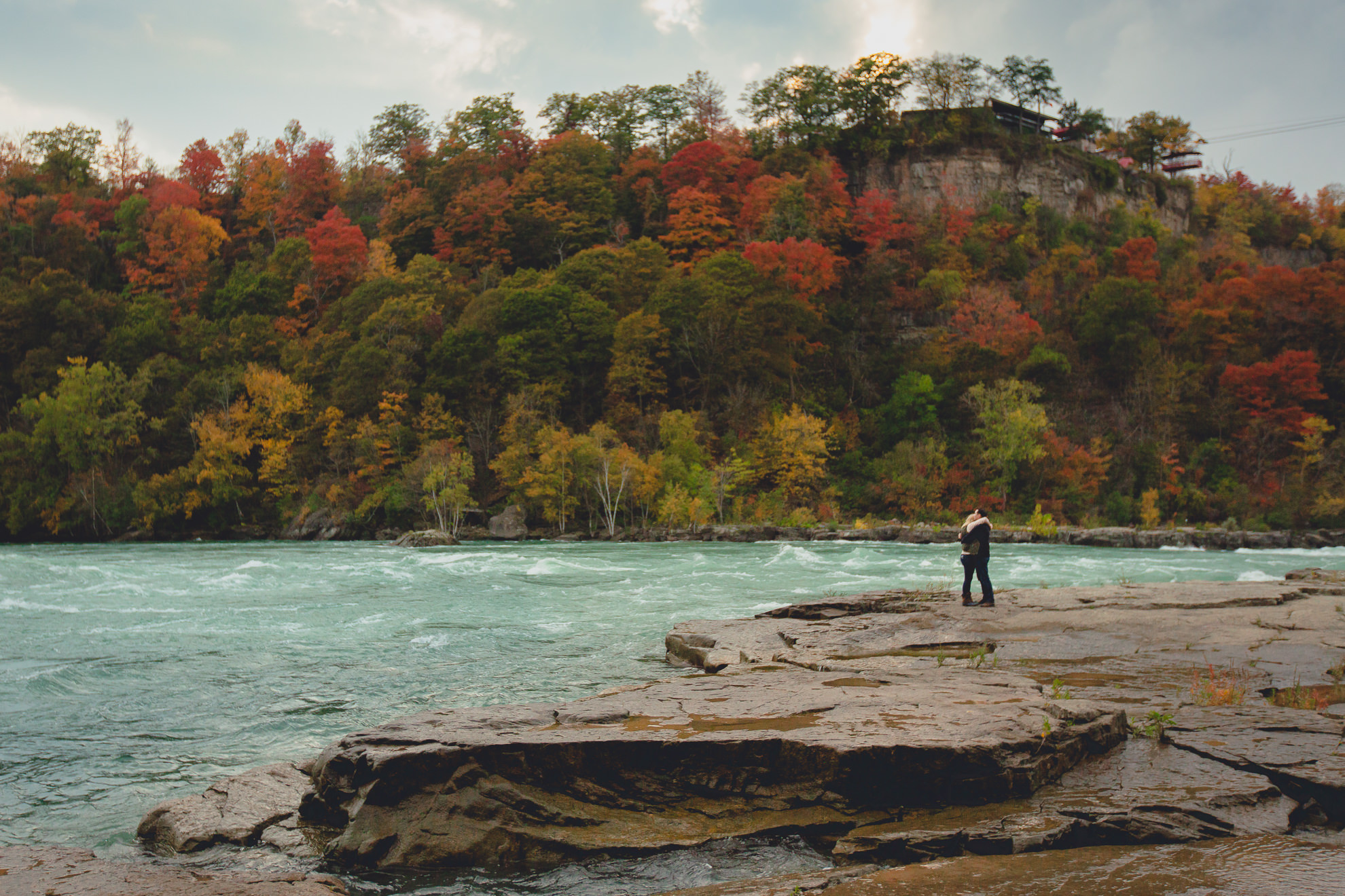 wedding engagement proposal photography with rapids and fall foliage in background at Whirlpool State Park in Niagara Falls, NY