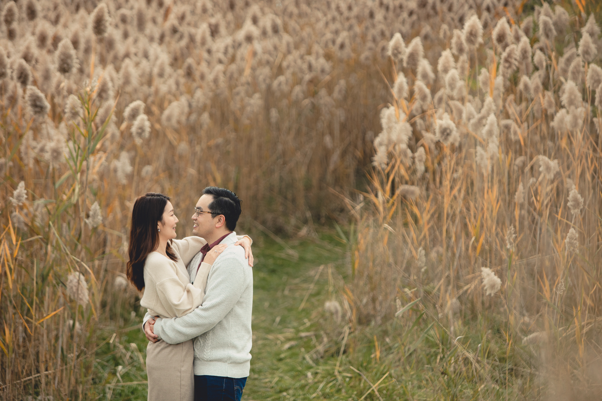 bride and groom embrace in front of cat tails after wedding engagement proposal at Tifft Nature Preserve in Buffalo, NY