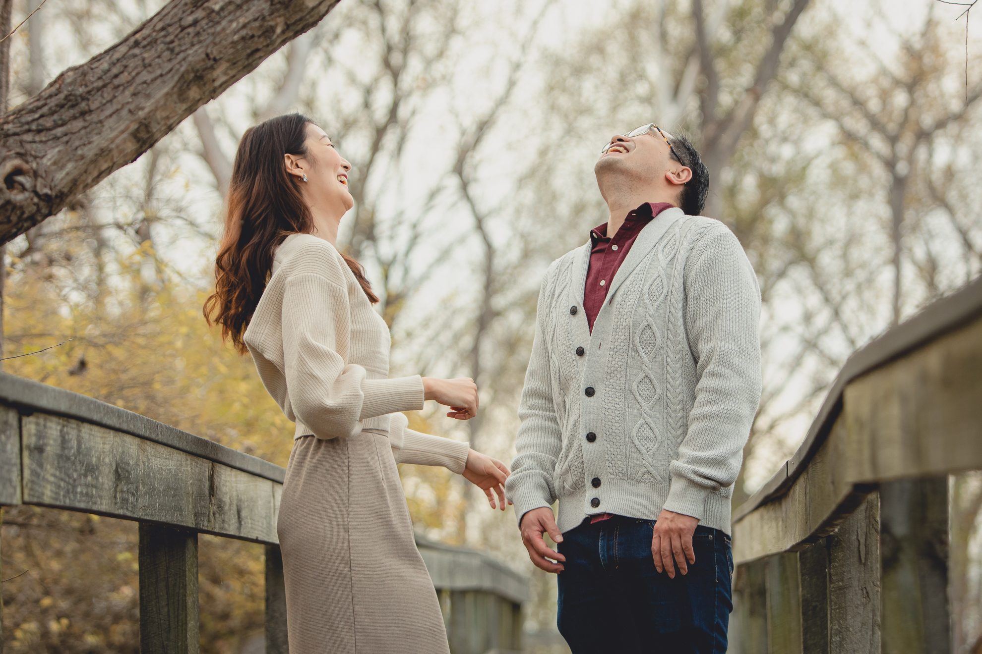 bride and groom laugh during engagement photography session among fall foliage in Tifft Nature Preserve in Buffalo, NY