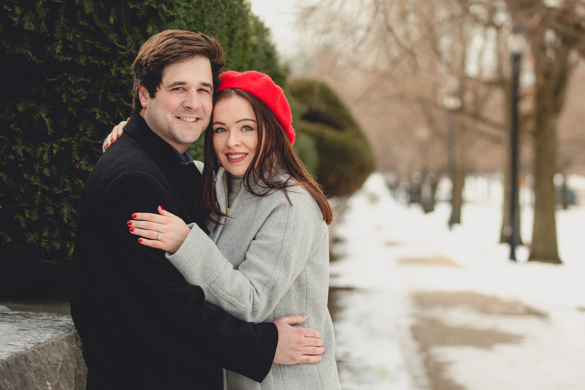 bride and groom smile for photographer on Lincoln Parkway in Delaware Park during their wedding engagement photography session in Buffalo, NY