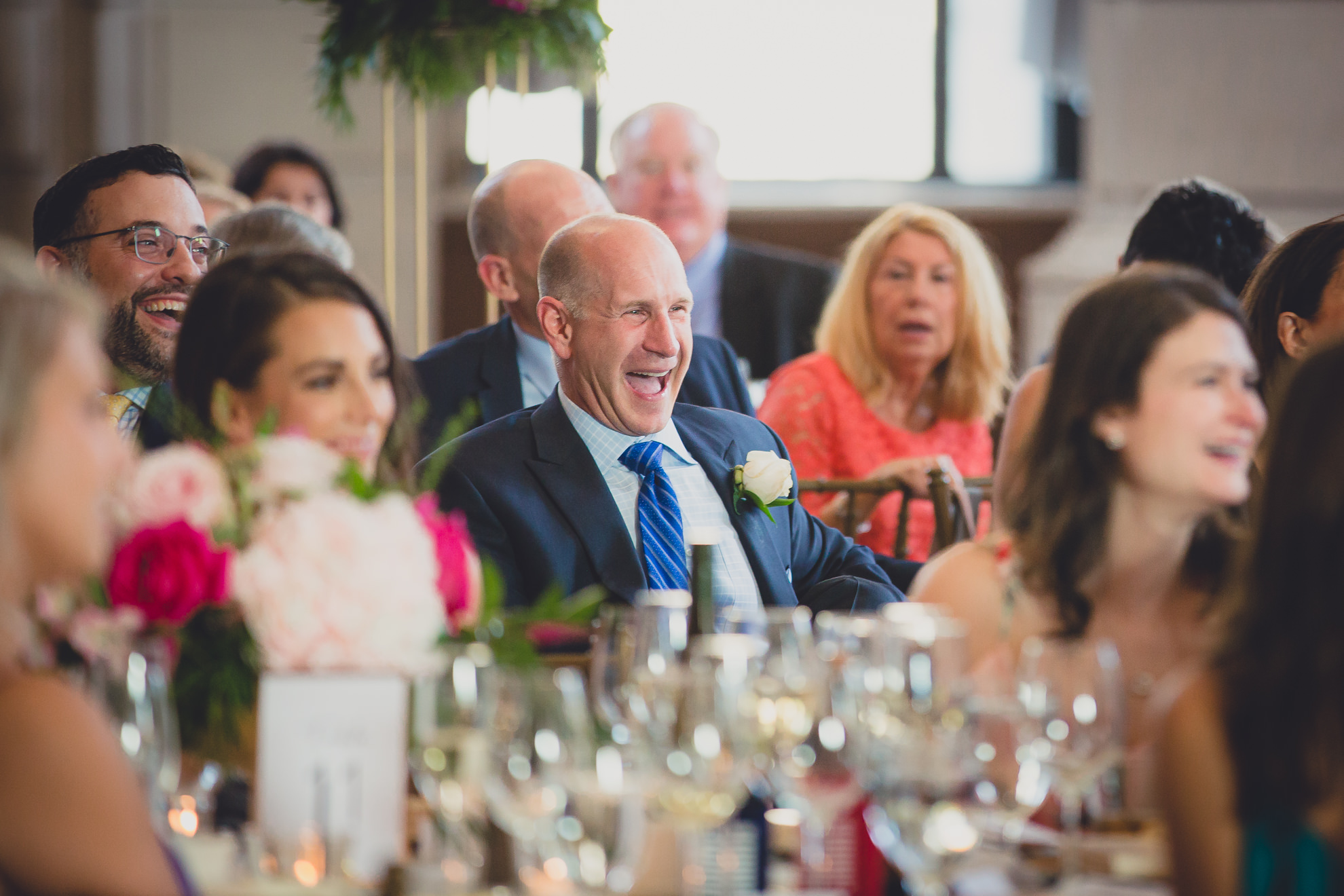 guests smile at bride and groom during speech at Admiral Room Ballroom wedding reception venue in downtown Buffalo, NY