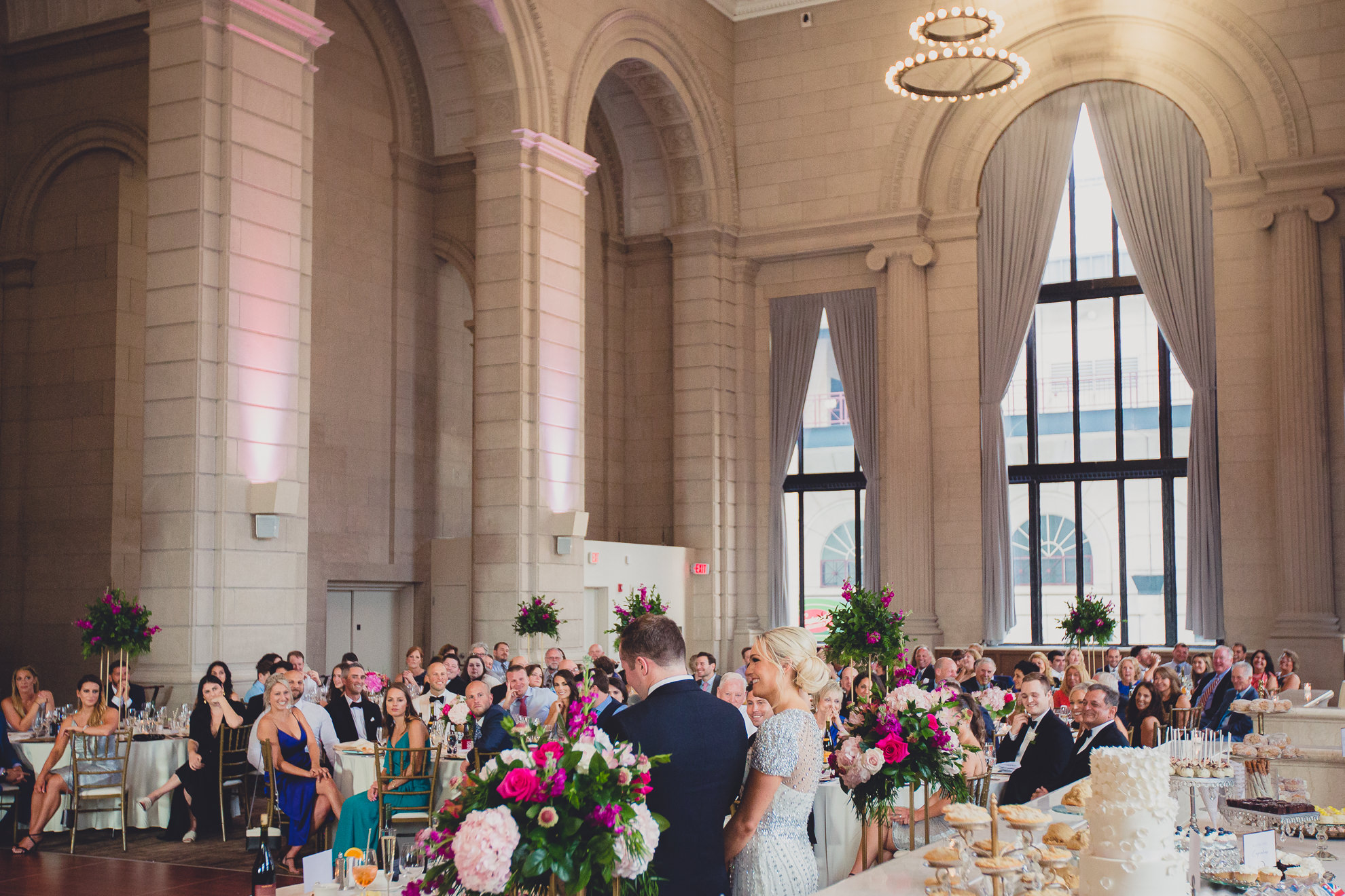 guests smile at bride and groom during speech at Admiral Room Ballroom wedding reception venue in downtown Buffalo, NY