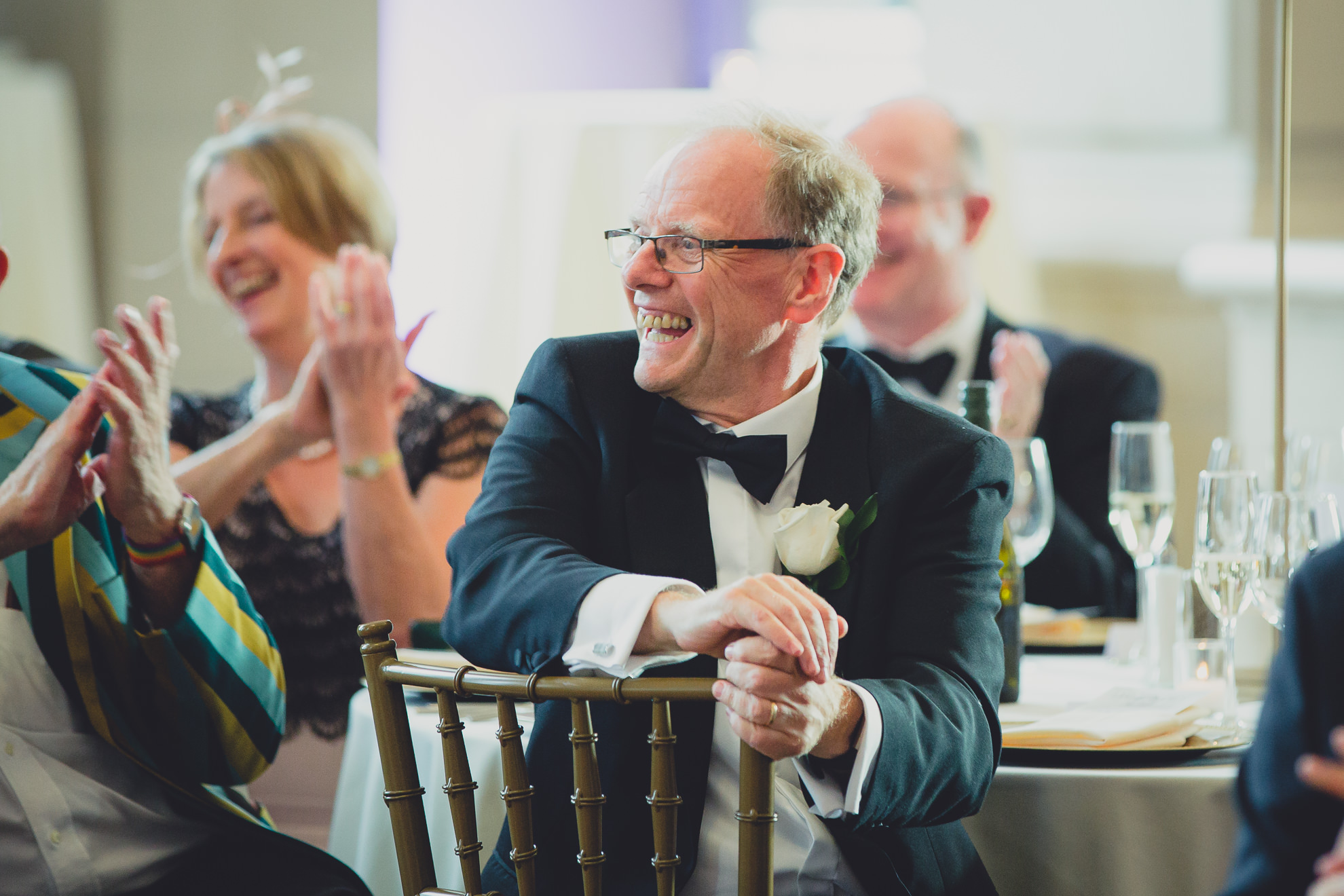 guests smile at bride and groom during speech at Admiral Room Ballroom wedding reception venue in downtown Buffalo, NY