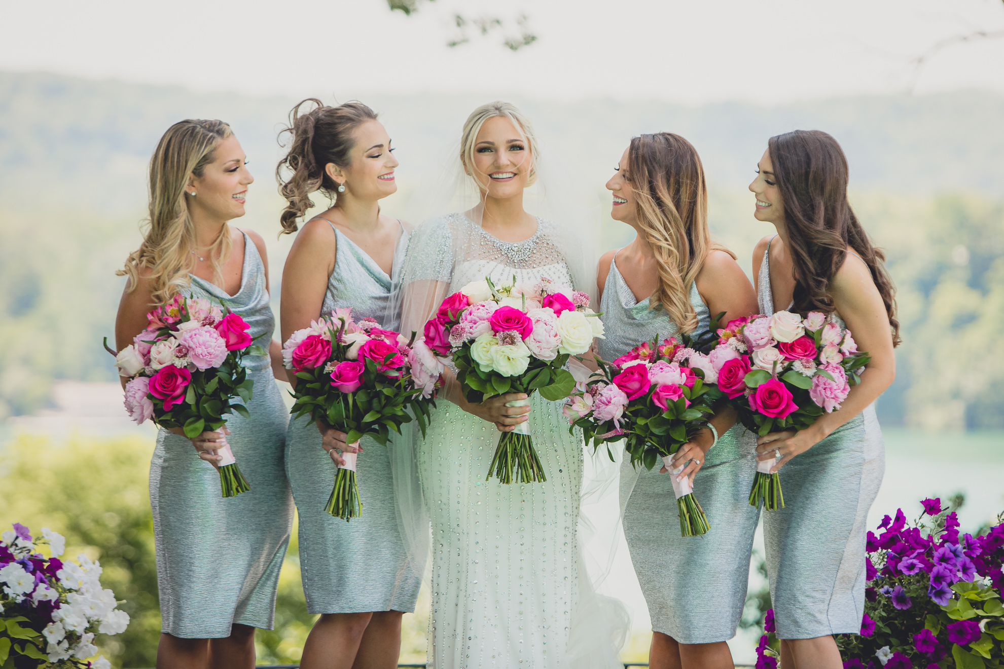 bride poses for portrait with bridesmaids in backyard along the Niagara River in Lewiston, NY