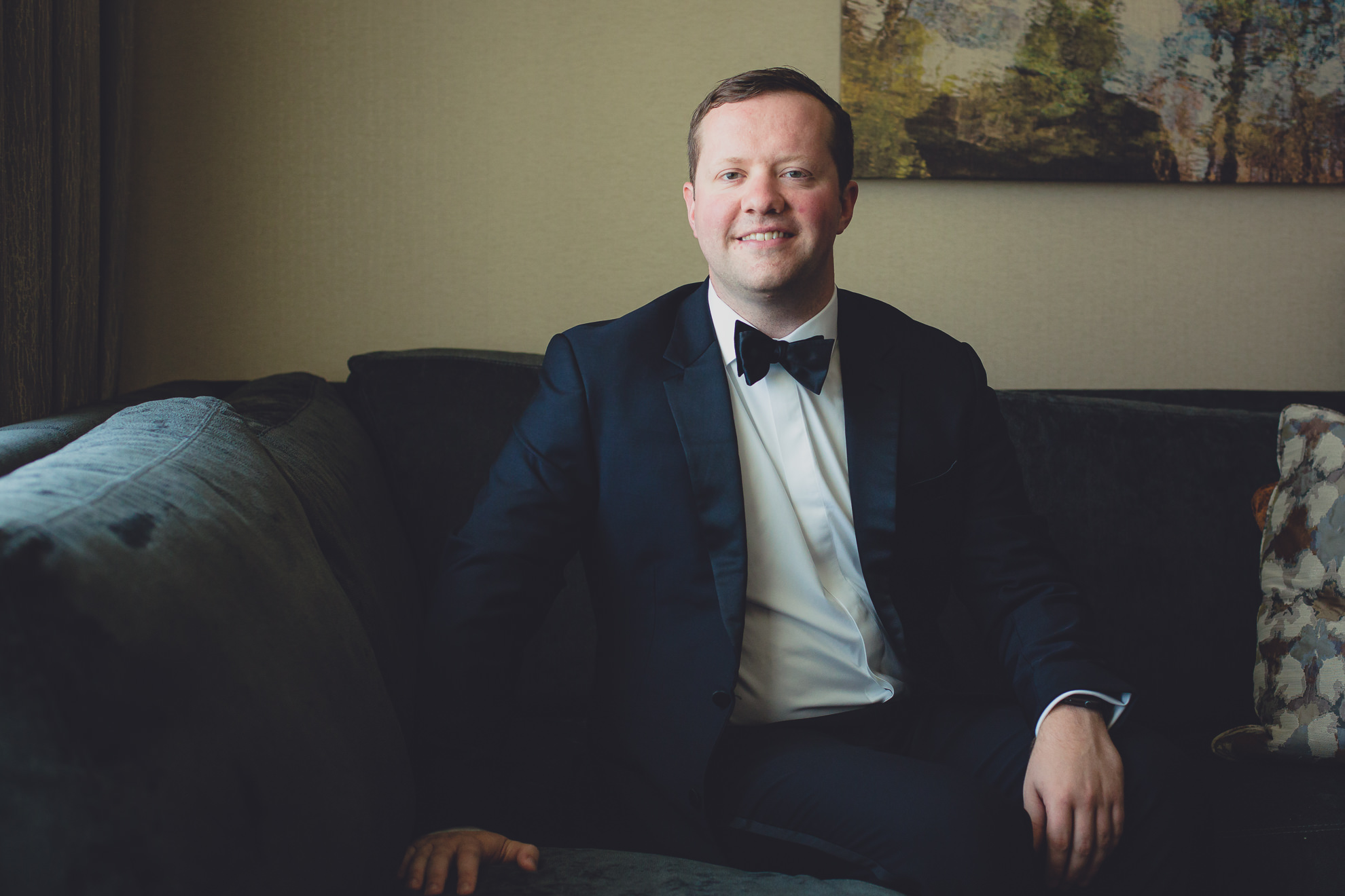 groom poses for photographer before wedding ceremony at the Westin Hotel in Buffalo, NY