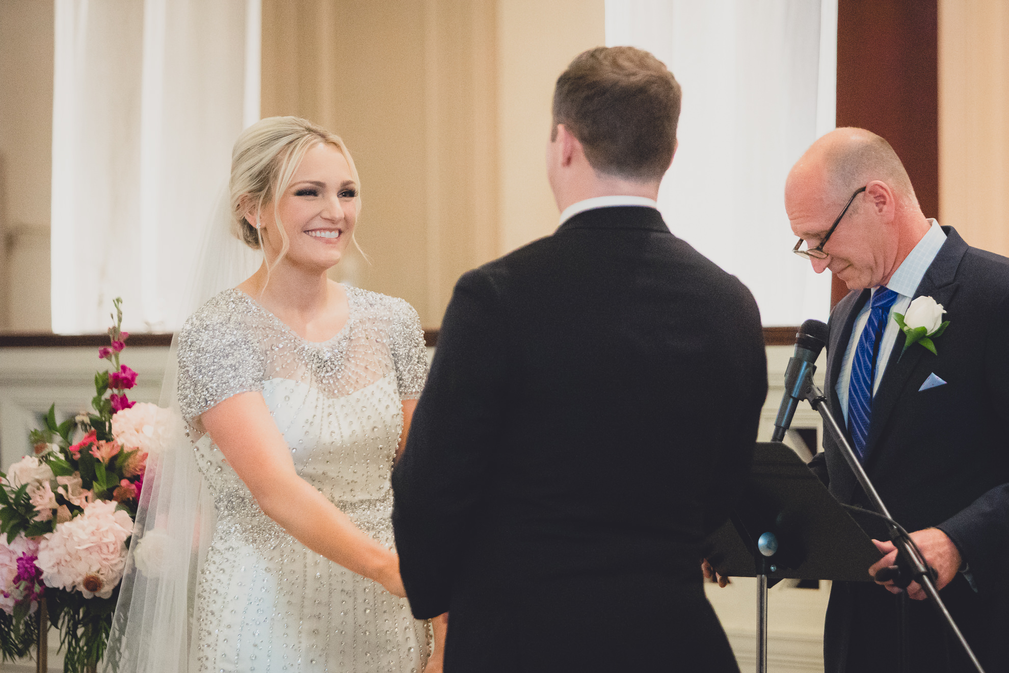 bride smiles at groom during wedding ceremony at Karpeles Manuscript Library in Buffalo, NY