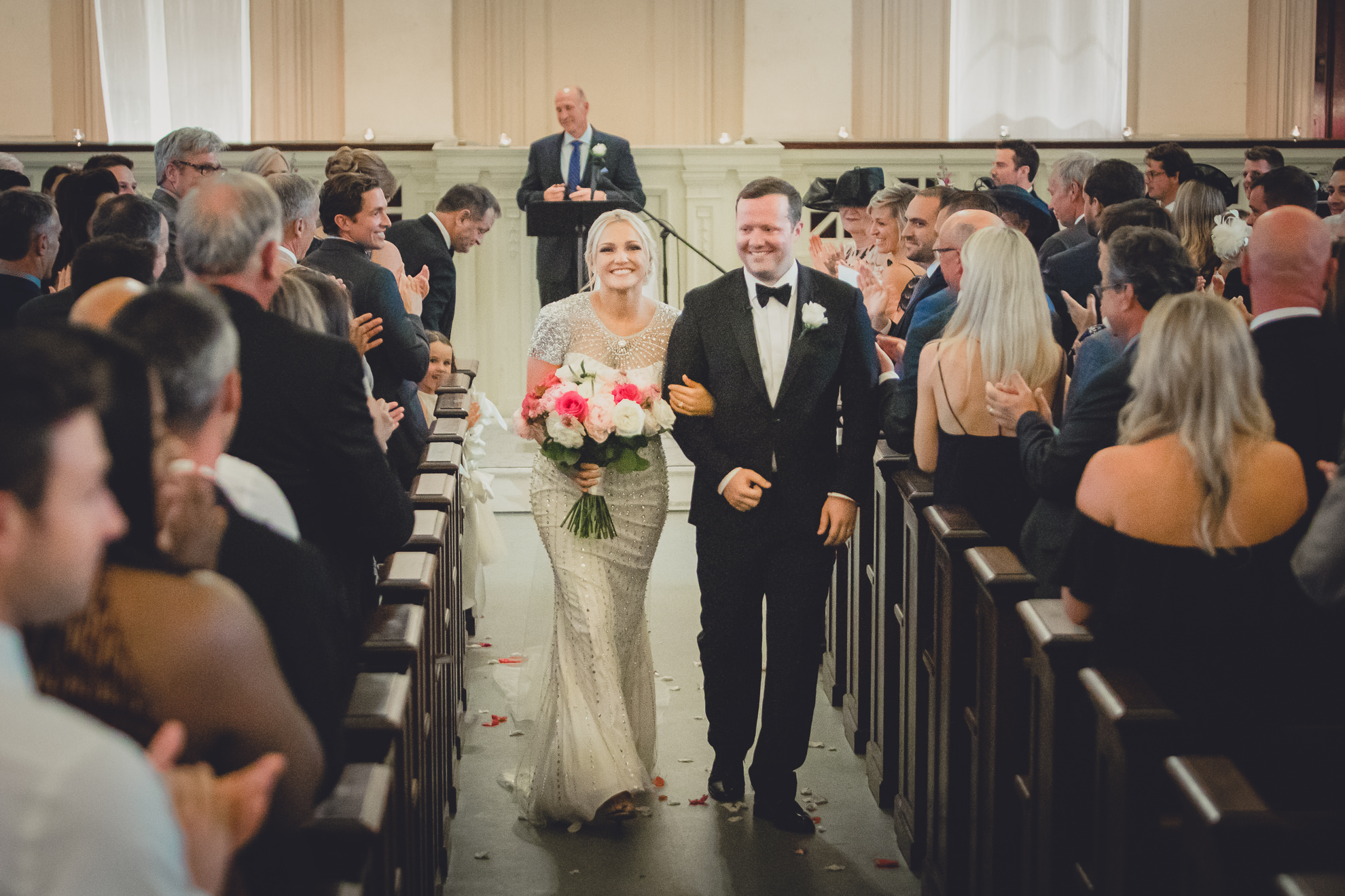 bride and groom walk down aisle during wedding ceremony at Karpeles Manuscript Library in Buffalo, NY