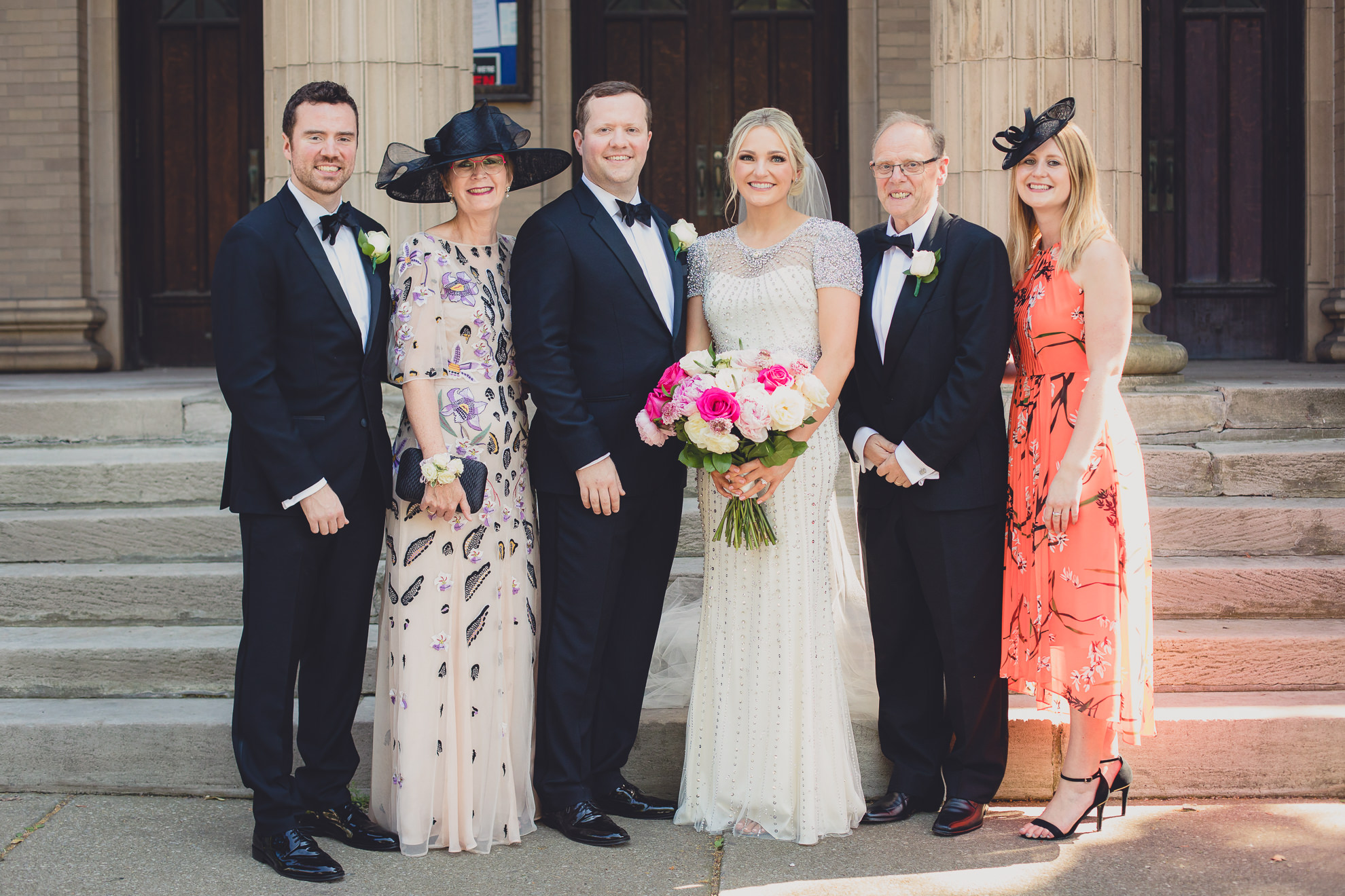 family poses for portrait on front steps of Karpeles Manuscript library after wedding ceremony in Buffalo, NY