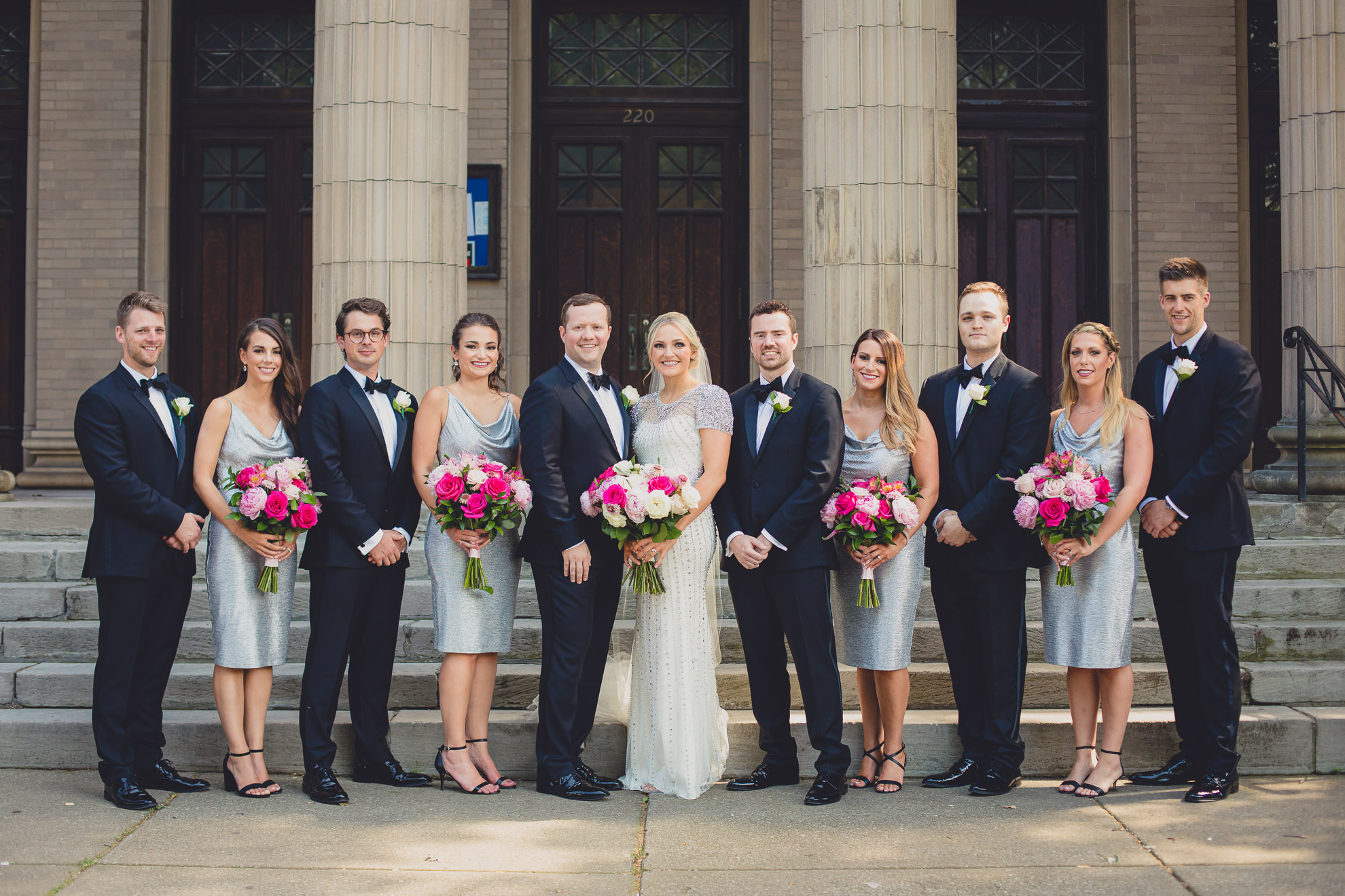 wedding party poses for portrait on front steps of Karpeles Manuscript library in Buffalo, NY